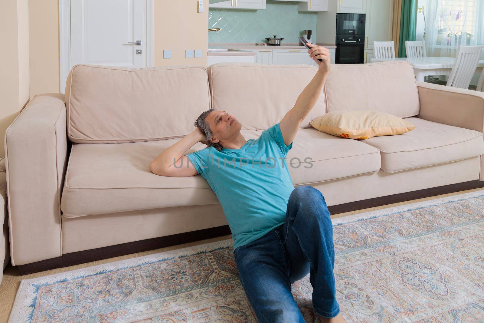 An adult man on the phone talking on video in an apartment.