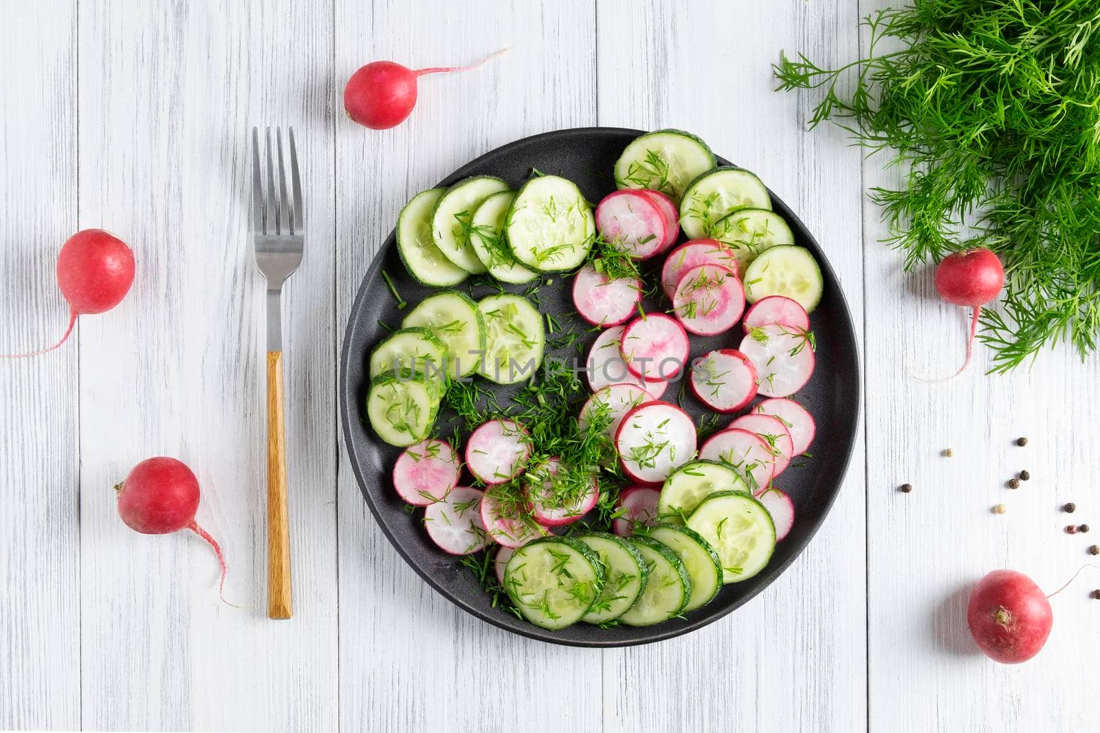Top view of fresh cucumber and radish salad with dill and vegetable oil. Vegetarian diet. Diesta for weight loss. Healthy eating. Selective focus.