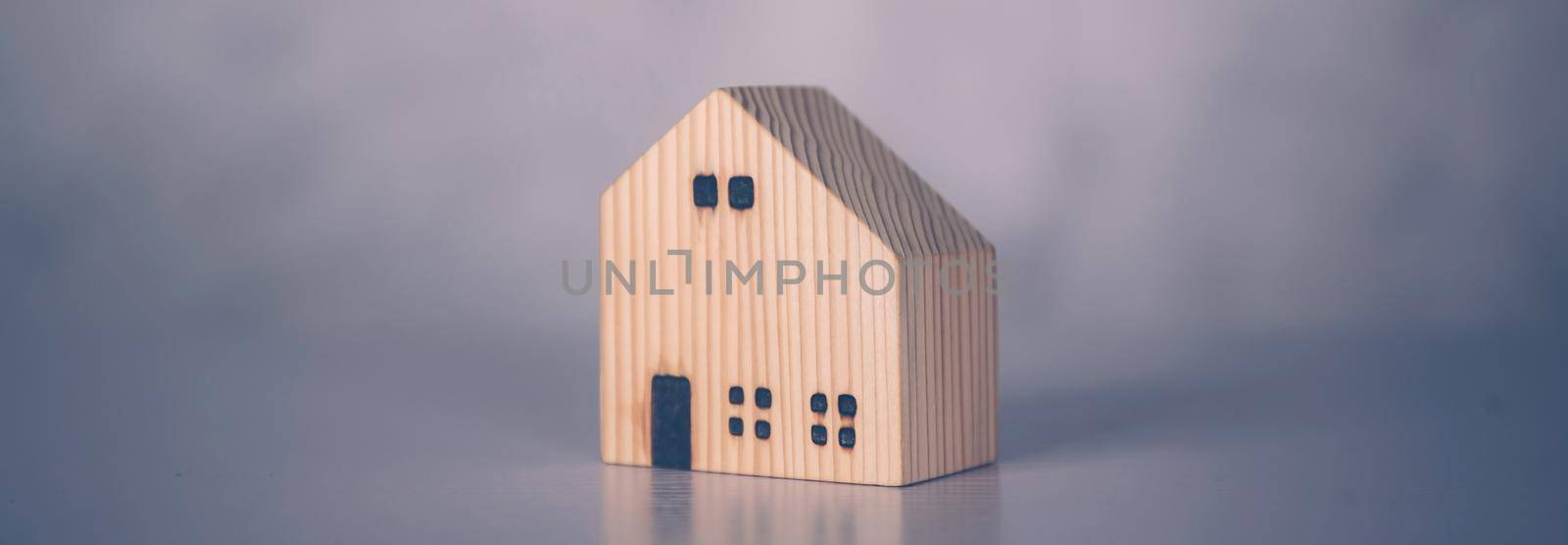 Mini wooden home model concept, investment of real estate and asset, tax of property and rental for finance, no people, small house and inspiration, mortgage and loan for residence, business concept. by nnudoo