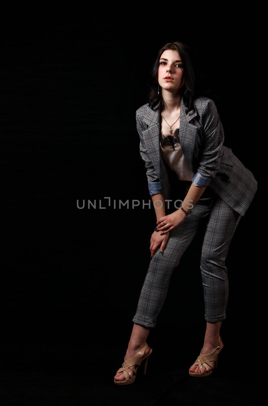 young beautiful girl in a business suit posing standing in the studio by raddnatt