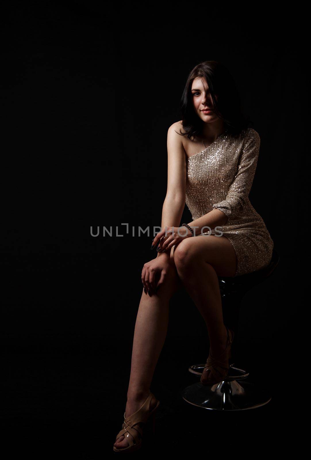 young beautiful girl posing sitting on chair in the studio by raddnatt