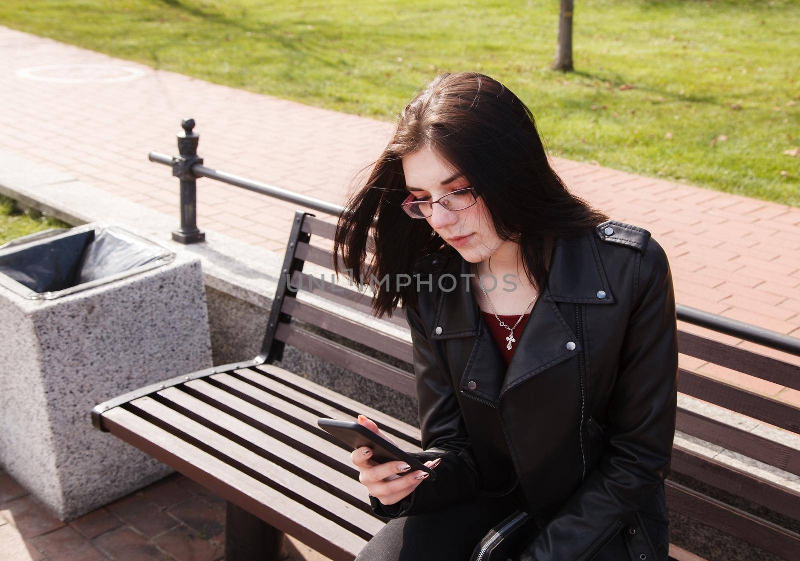 young girl display while sitting on bench in city park by raddnatt