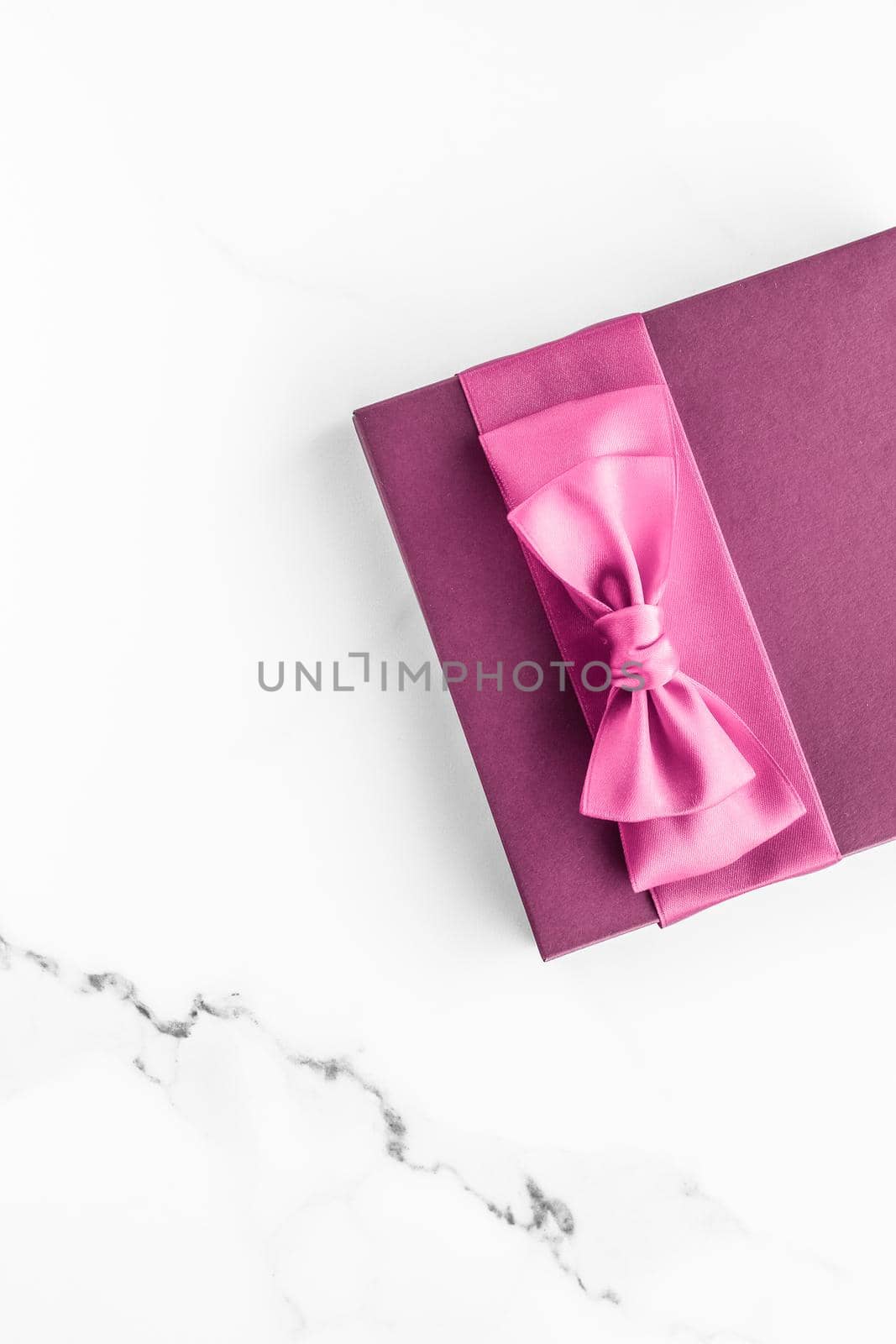 Pink gift box with silk bow on marble background, girl baby shower present and glamour fashion gift for luxury beauty brand, holiday flatlay art design by Anneleven