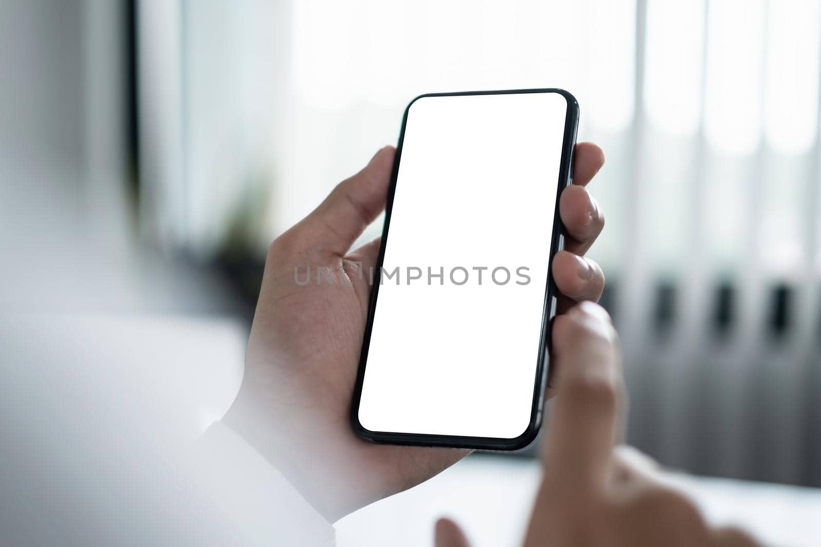 A Man hand holding smartphone device with blank screen. by itchaznong