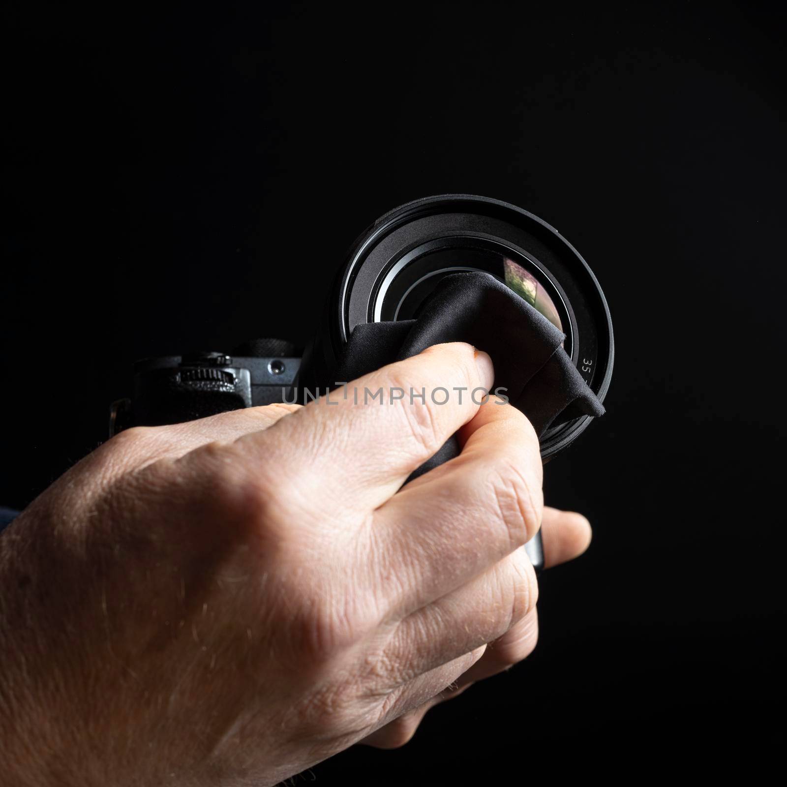 a man cleaning the front lens of a camera lens