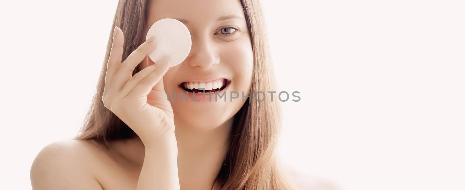 Beautiful woman with cotton pad, perfect skin and shiny hair as make-up, health and wellness concept. Face portrait of young female model for skincare cosmetics and luxury beauty ad design.