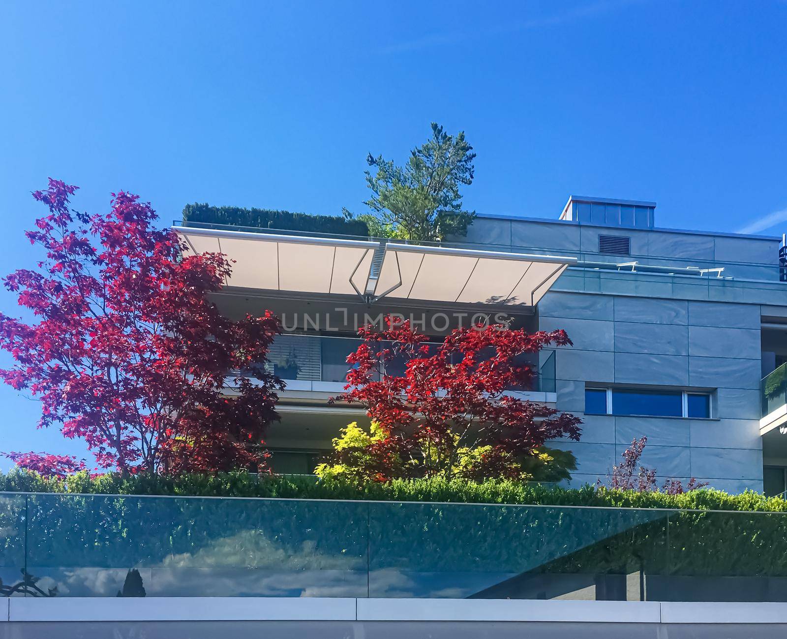 Wollerau, canton of Schwyz, Switzerland circa June 2021: Modern apartment buildings and street, Swiss architecture and real estate