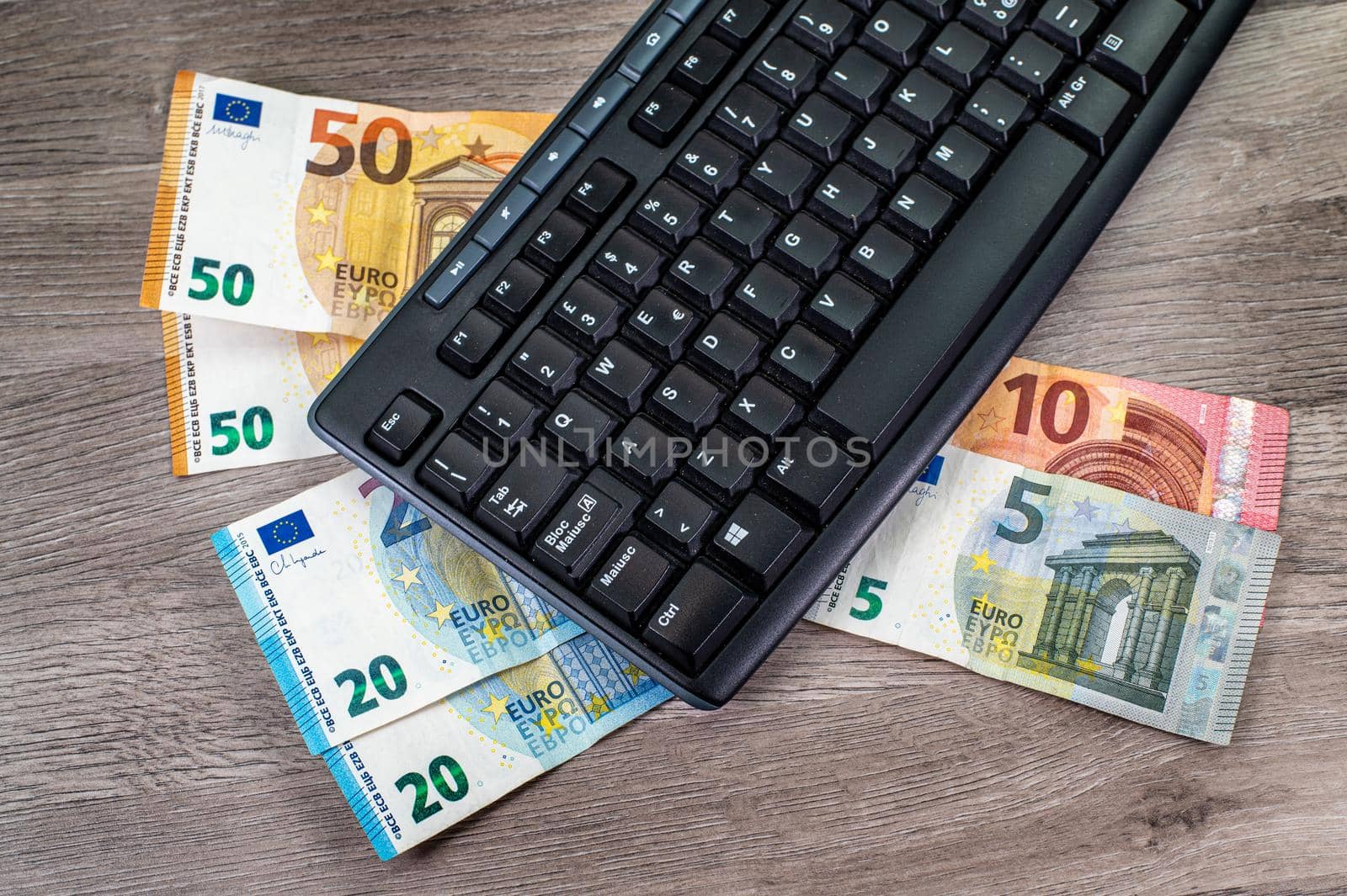 euro banknotes of different denominations and computer keyboard