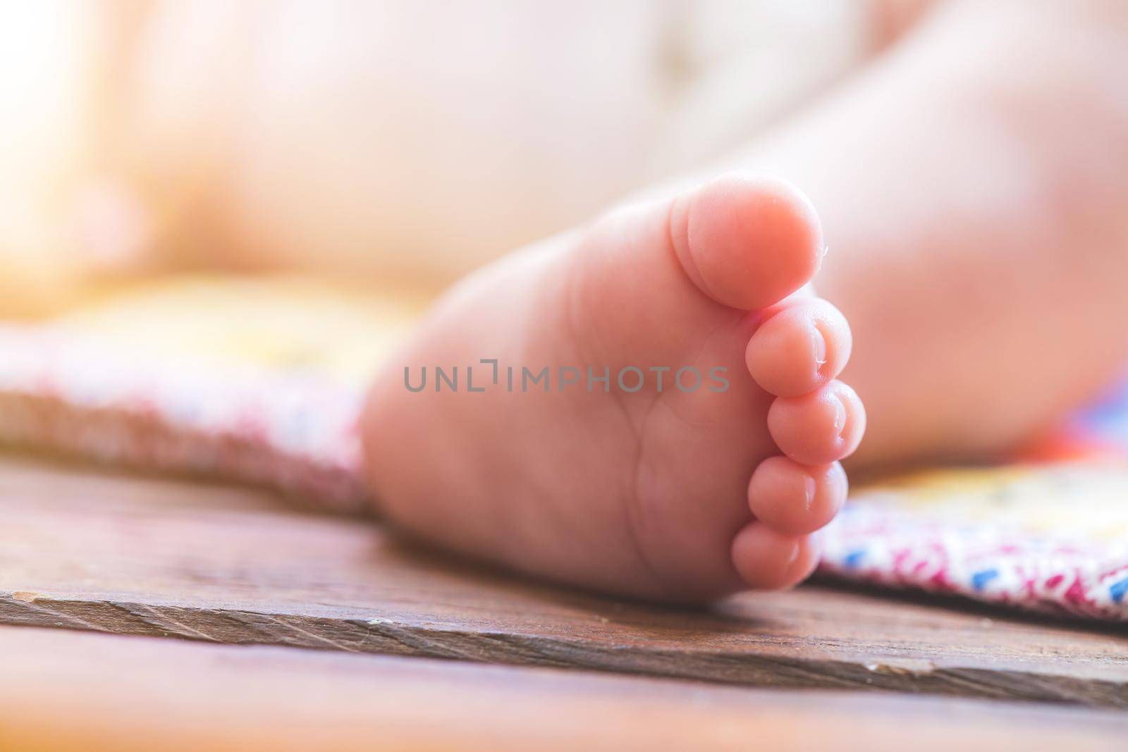 Close up of newborn baby feet, outdoors on baby blanket