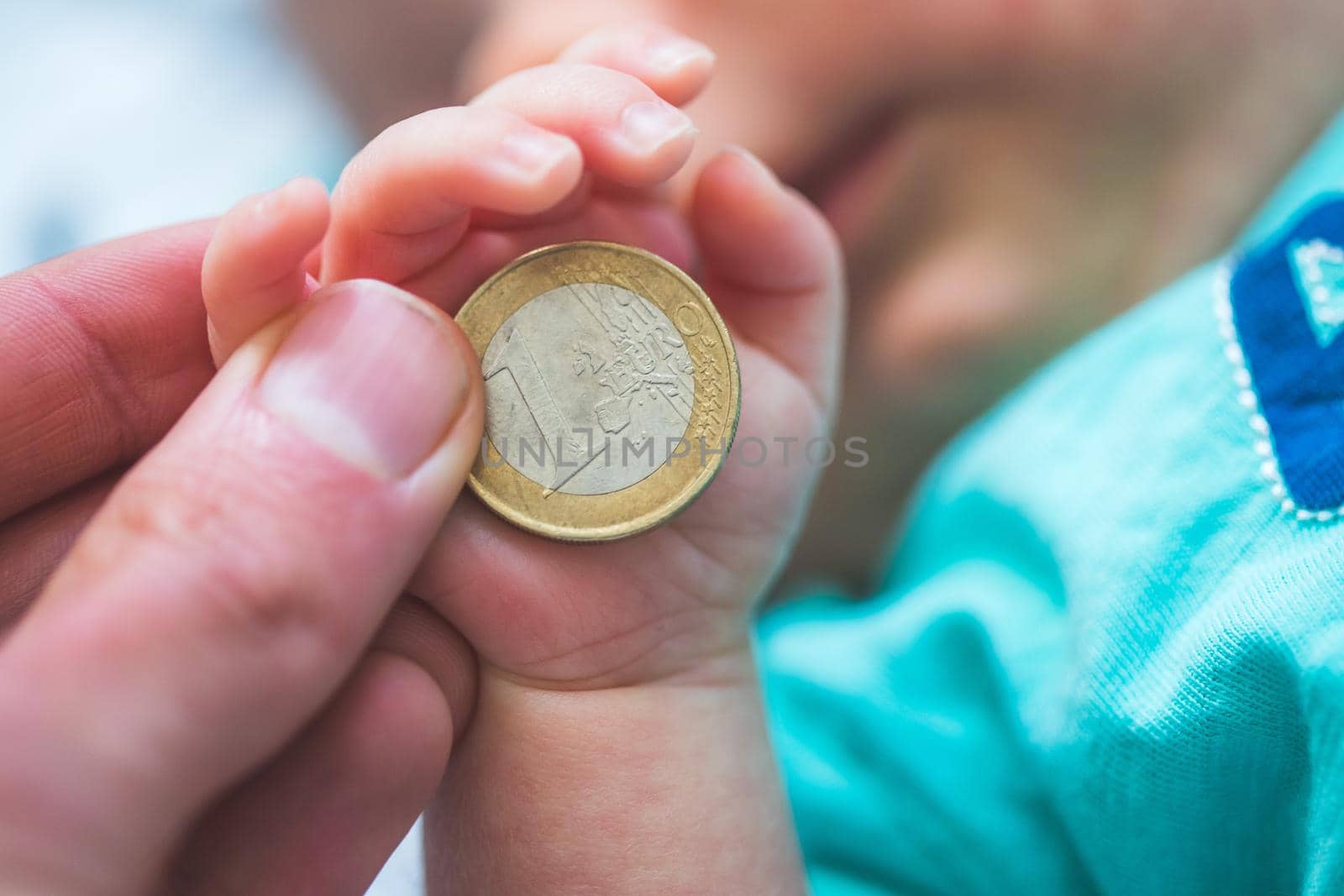 Old age insurance baby concept: Close up of newborn baby holding a coin by Daxenbichler