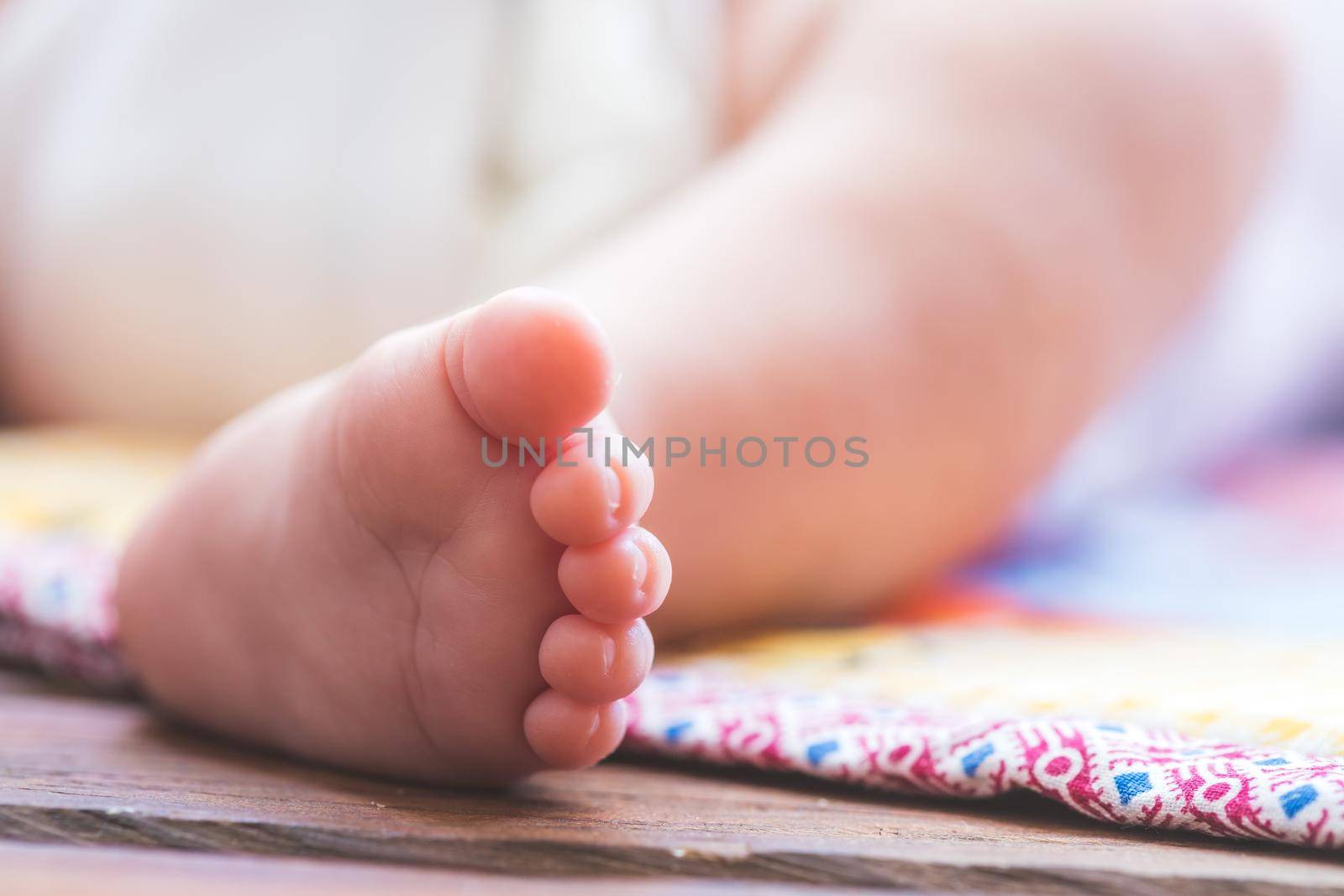 Close up of newborn baby feet, outdoors on baby blanket