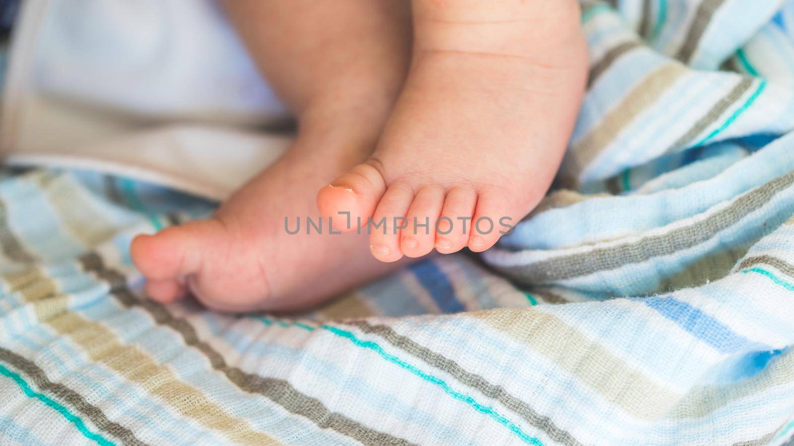 Close up of newborn baby feet on baby blanket