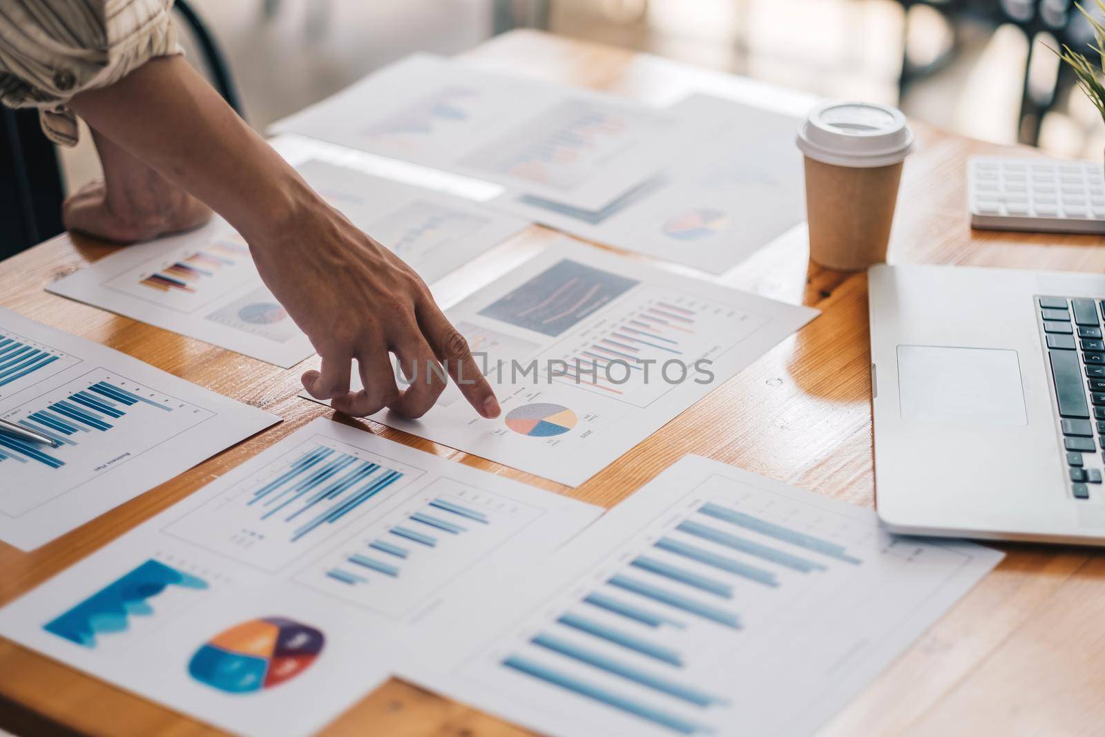 Businessman discussing analysis charts or graphs on desk table and using laptop computer.Close up male analysis and strategy concept. by nateemee