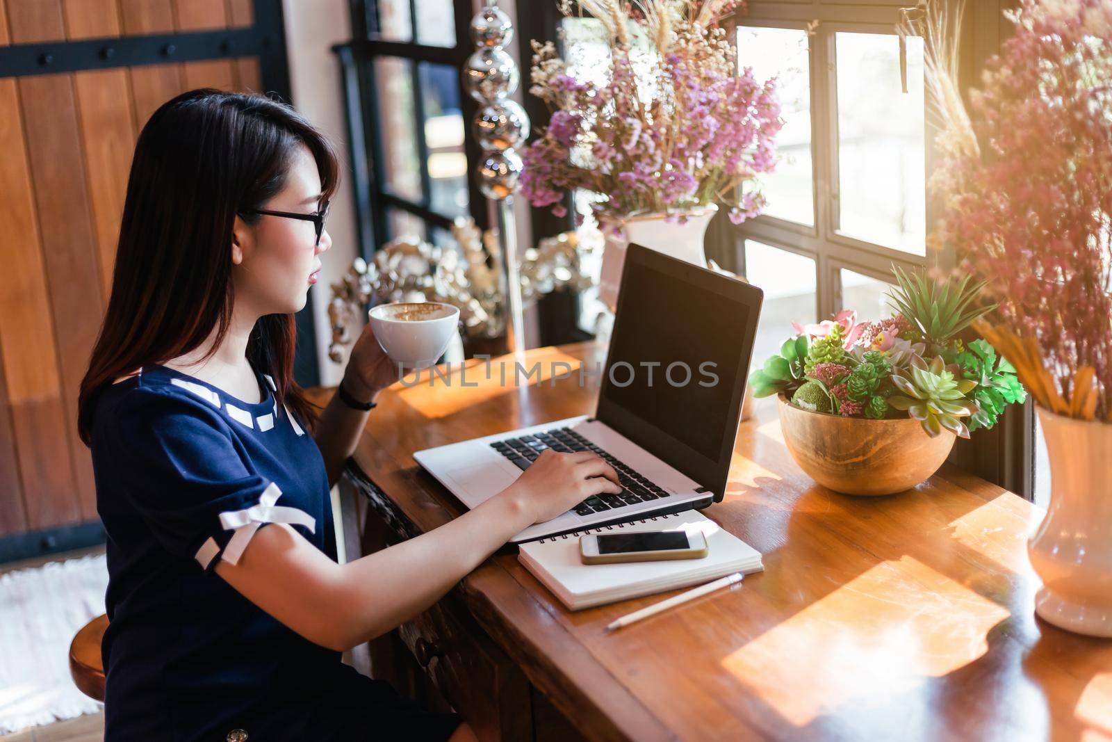 Asian business female hold a coffee mug working with laptop in coffee shop like the background. by tinapob2534