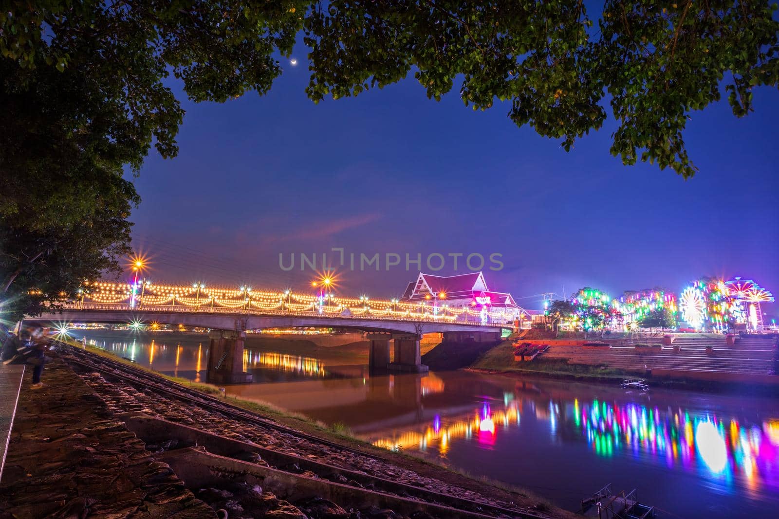 Beautiful light on the Nan River at night on the bridge (Naresuan Bridge) in Phitsanulok City,Thailand. by tinapob2534