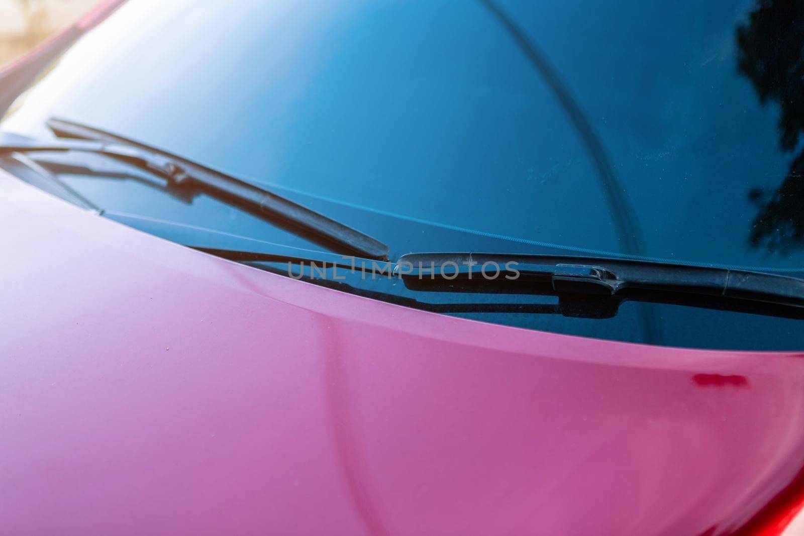 Closeup of window of red car outdoors.