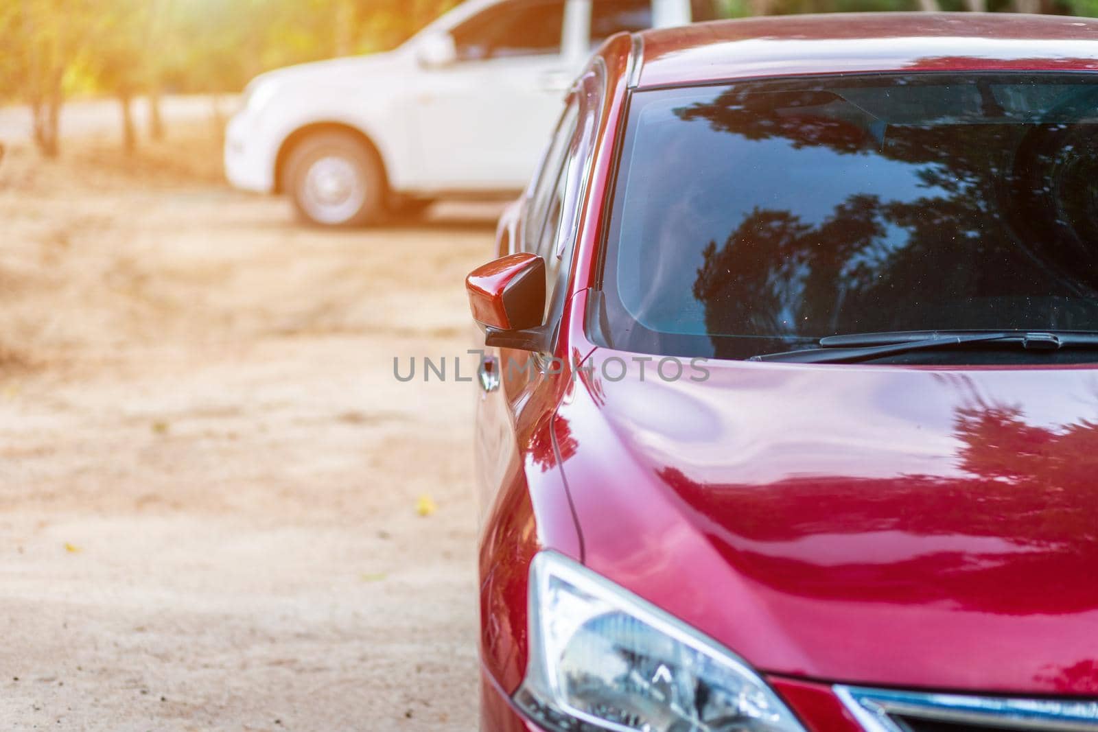 Closeup of headlight ,window of red car outdoors.