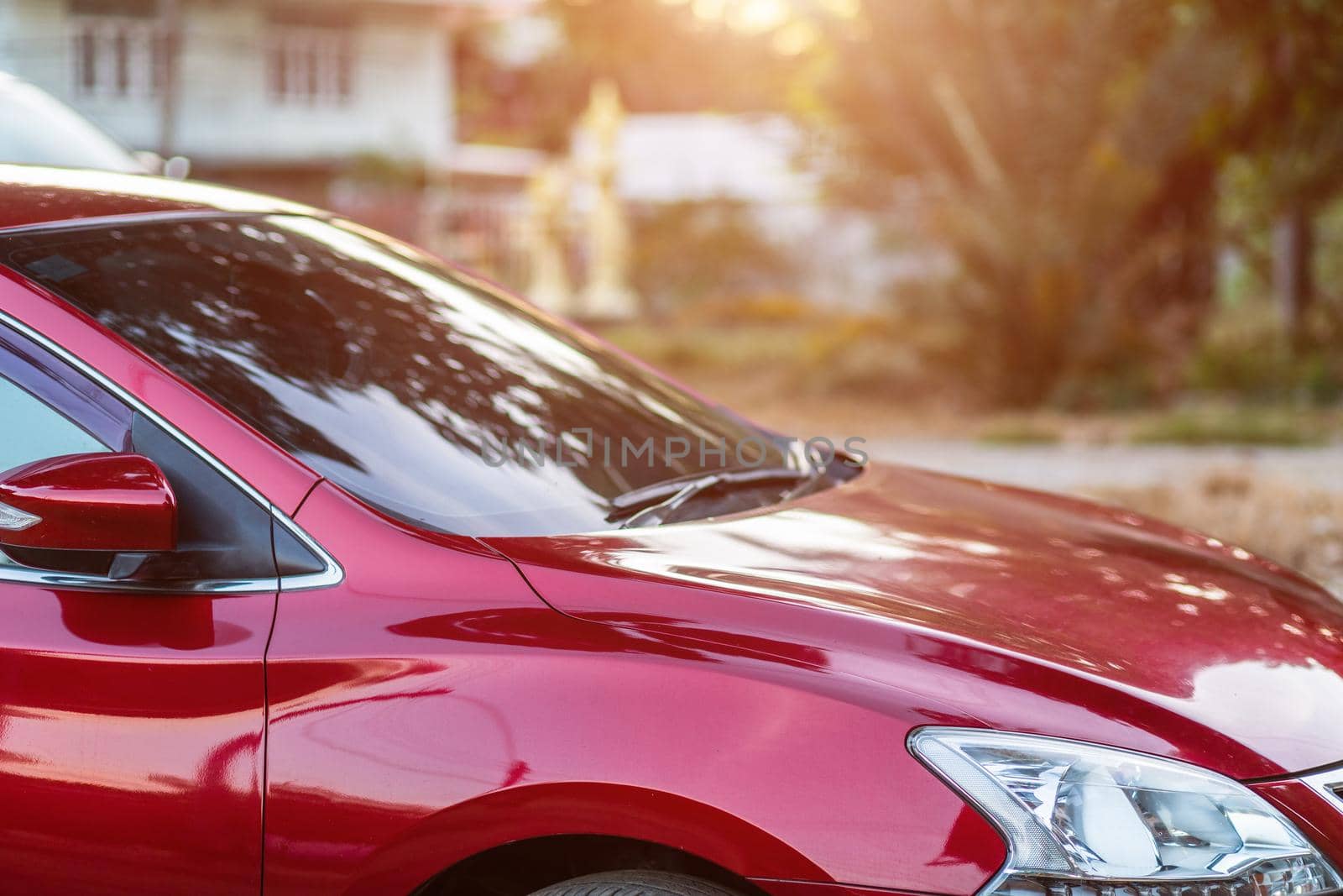 Closeup of headlight ,window of red car outdoors.