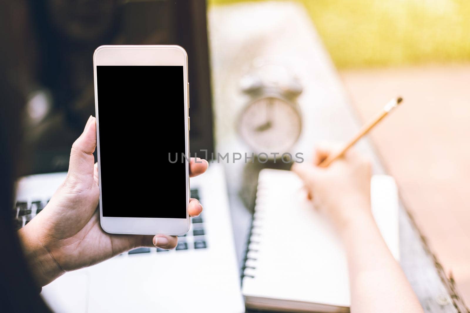 Close-up of Business female working with smartphone,laptop,clock and notebook on office outdoor.