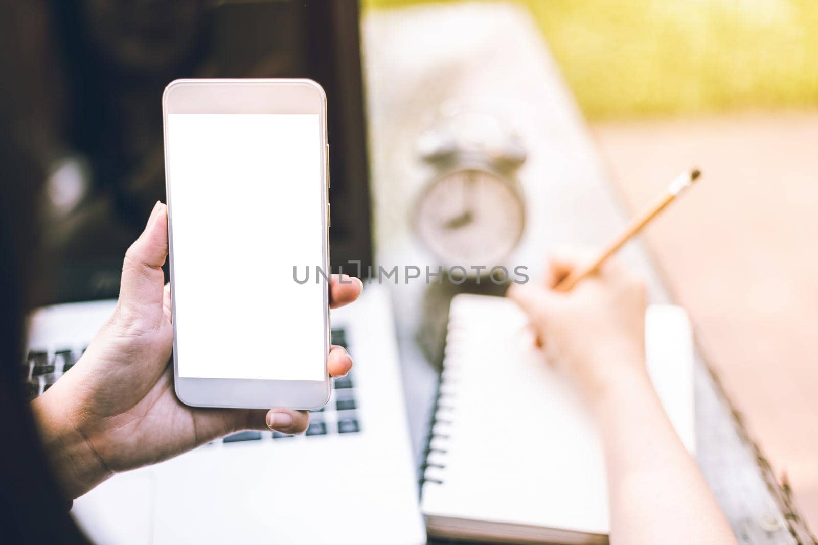 Close-up of Business female working with smartphone,laptop,clock and notebook on office outdoor.