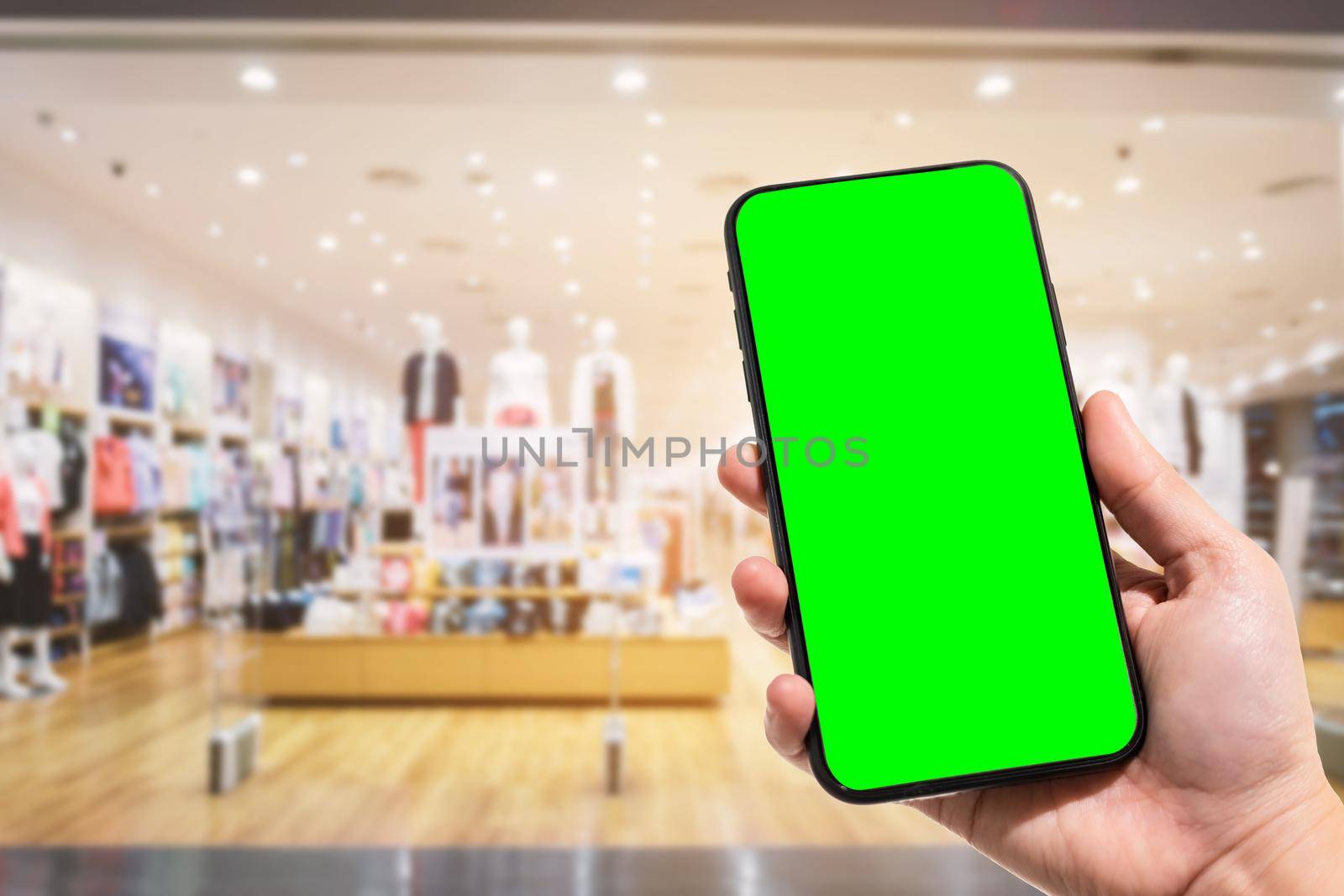 Close-up of female use smartphone blurred images in the mall and Clothes shop blur of the background. by tinapob2534