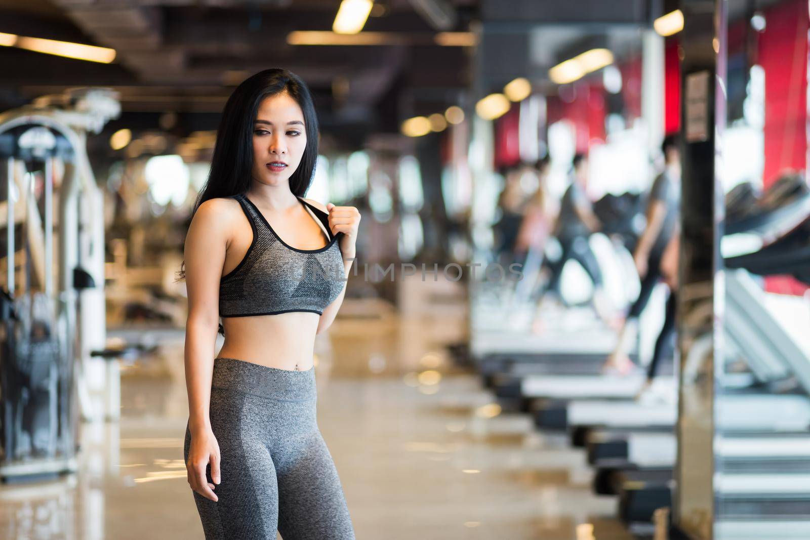 Fitness Asian women Stand in sport gym interior and fitness health club with sports exercise equipment Gym background.