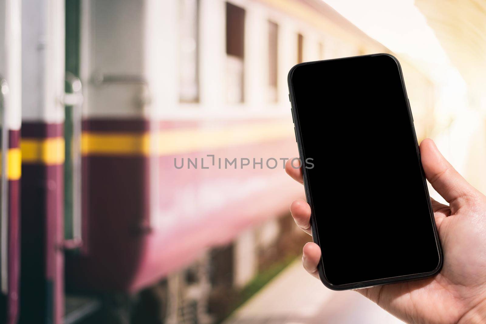 Close-up of female use Hand holding smartphone blurred images touch of Abstract blur of defocused in train station the background.