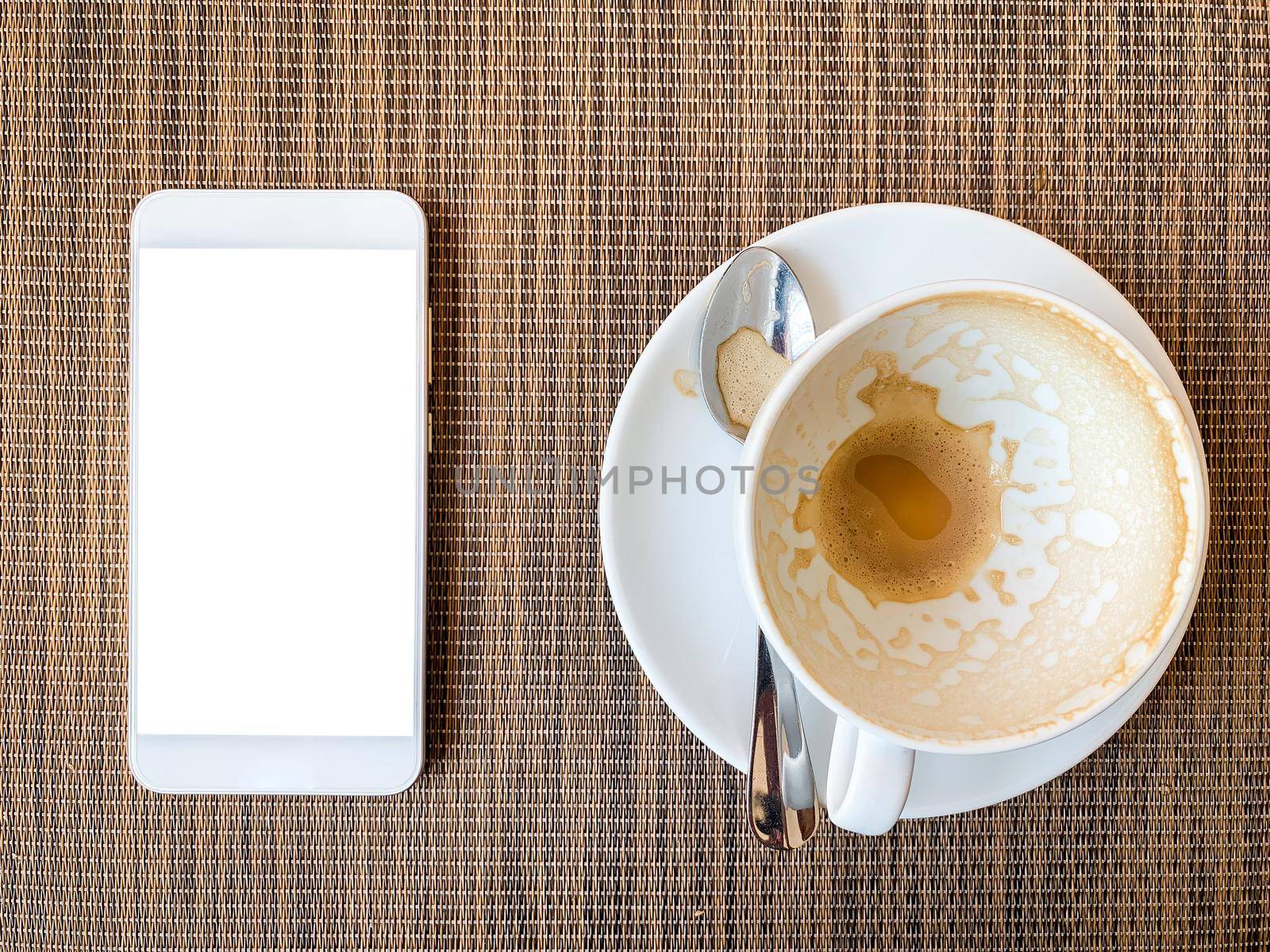 Smartphone and Empty coffee cup on wood desk on top view. 