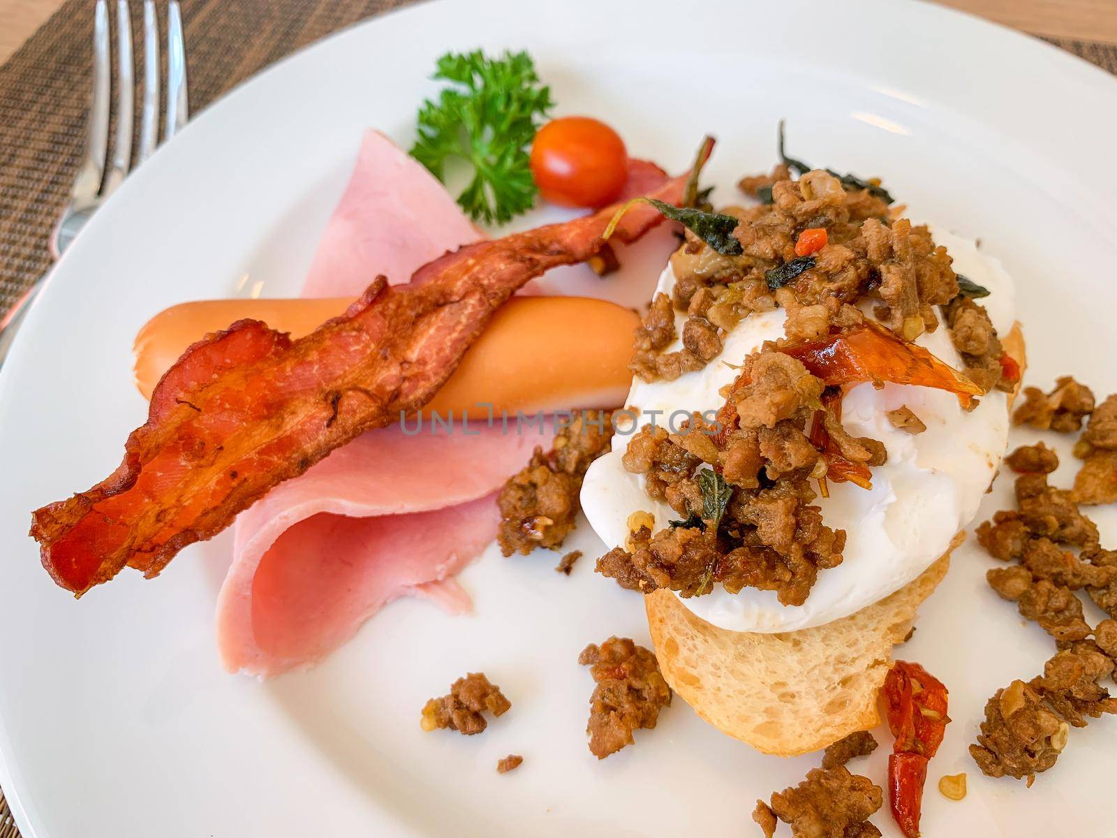 Breakfast, Kaprao fried pork with herb leaf on top Poached egg with bacon on toast, food thai.