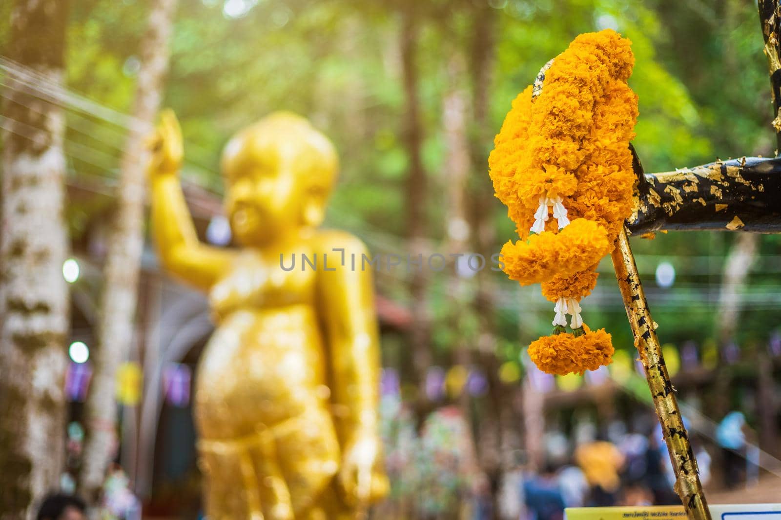 Marigold flower garland,Buddha statue beautiful On the way up at The stone with the footprint of Lord Buddha at Khitchakut mountain It is a major tourist attraction Chanthaburi, Thailand.
