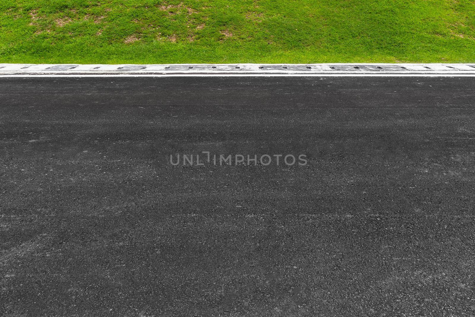 Asphalt road with stripes and green grass texture Background,empty copy space.