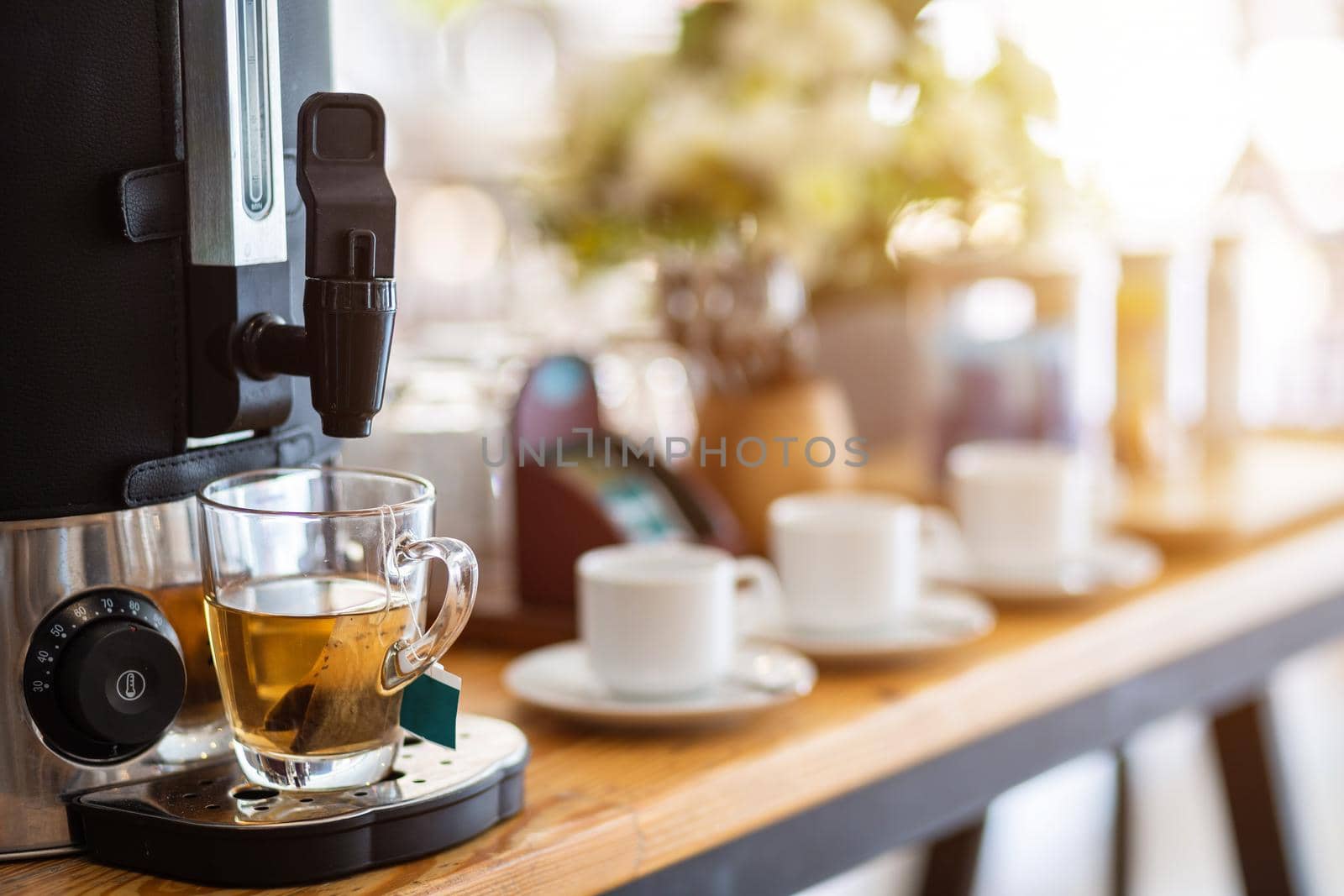 Close-up of tea from coffee machine and coffee cup on the dining table decoration at hotel