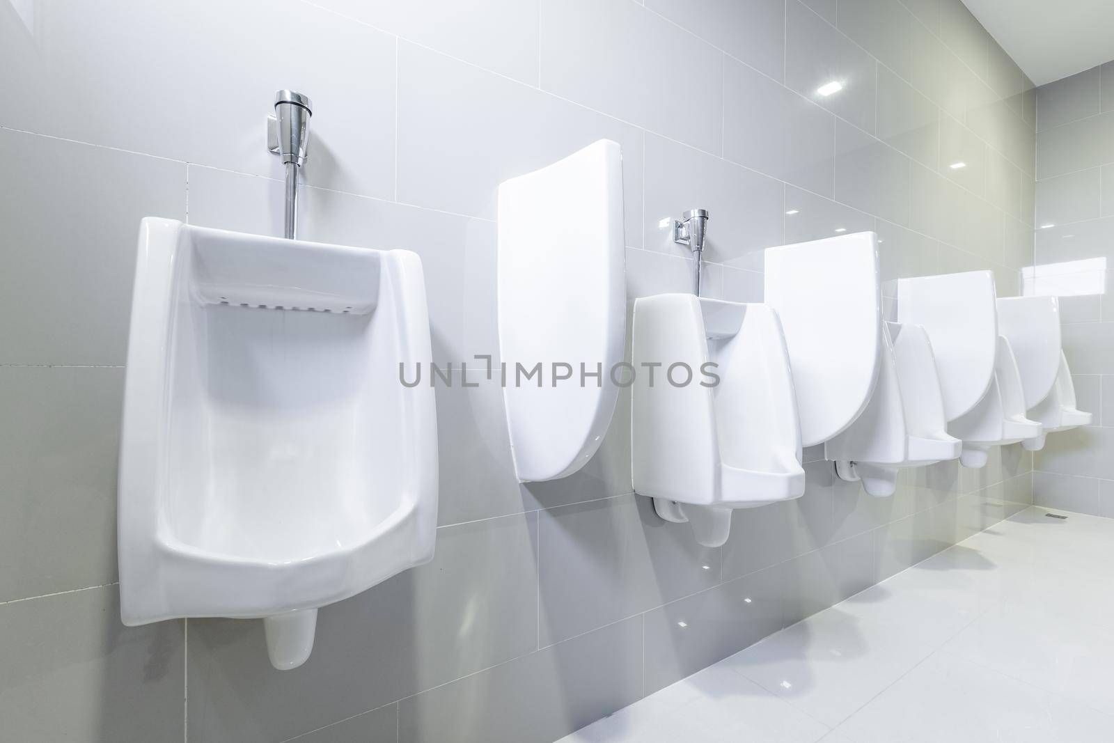 public toilet urinals lined up, no privacy.