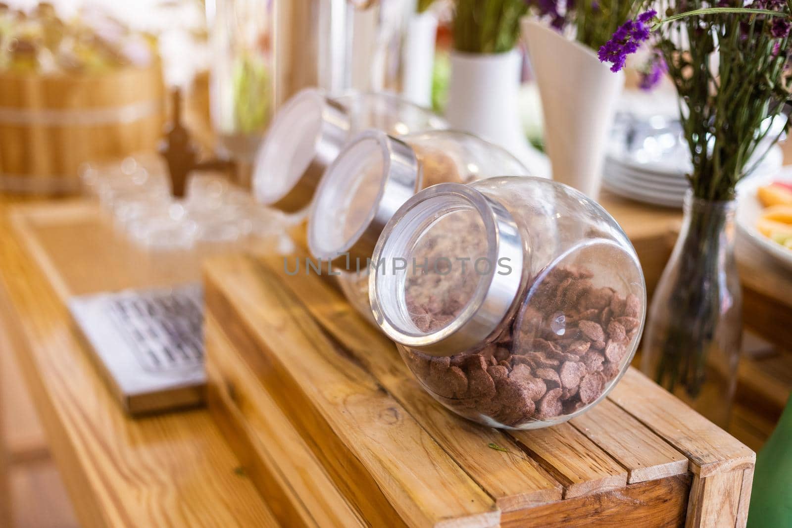 Long row Glass jars with breakfast cereal at on the dining table decoration at buffet self service at hotel.