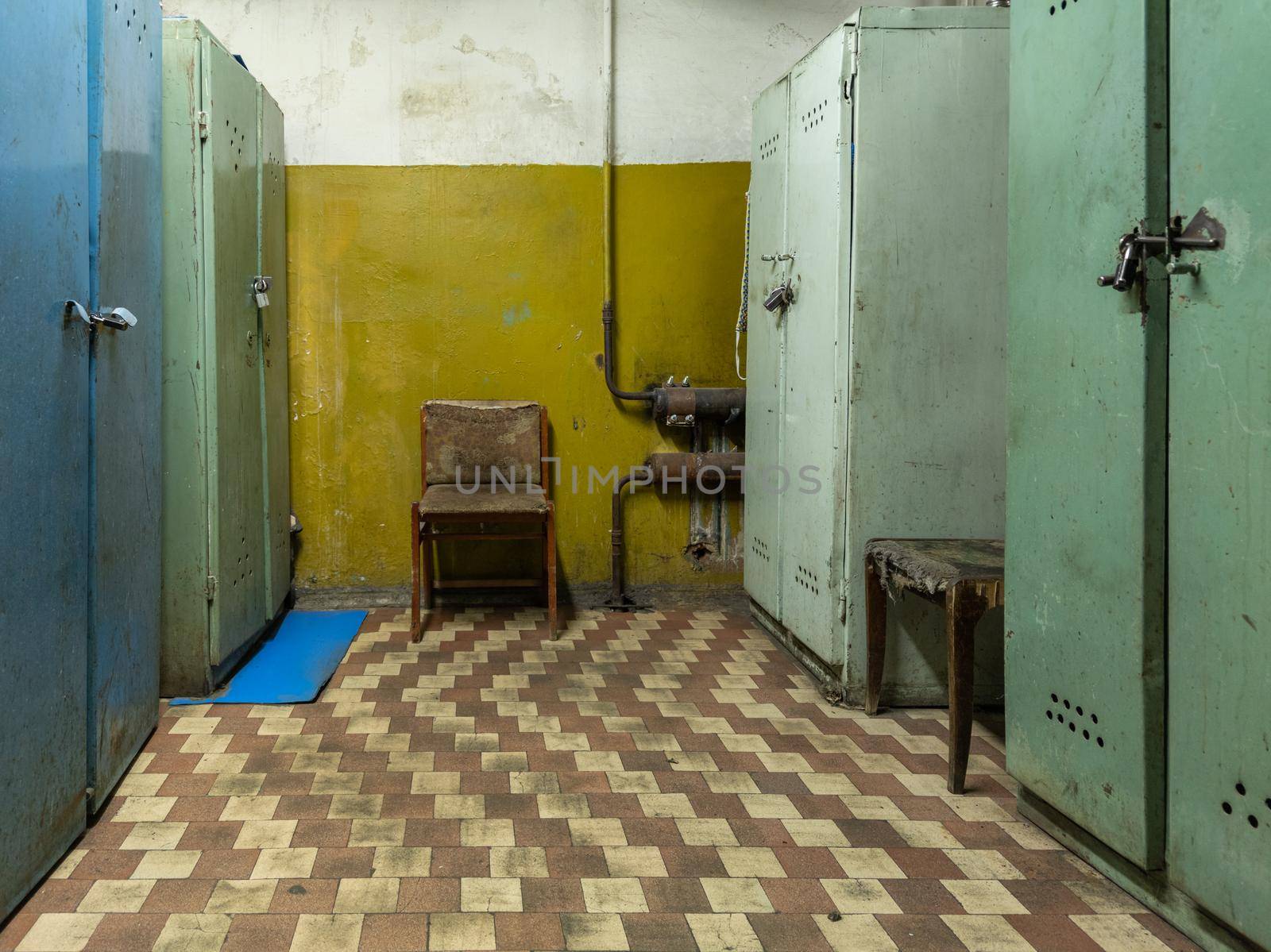 old dirty locker room in soviet factory with old chairs