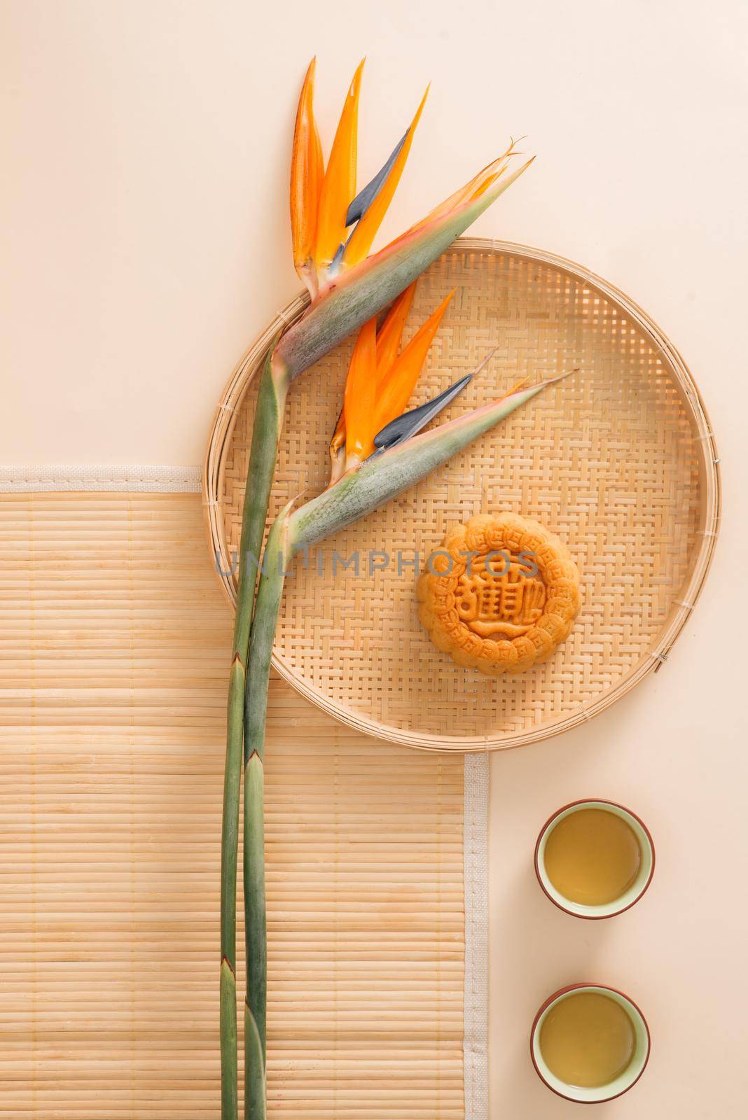 Flat lay conceptual mid autumn festival mooncake tea party table top shot on moody rustic background. Translation on round moon cake "Mid autumn".
