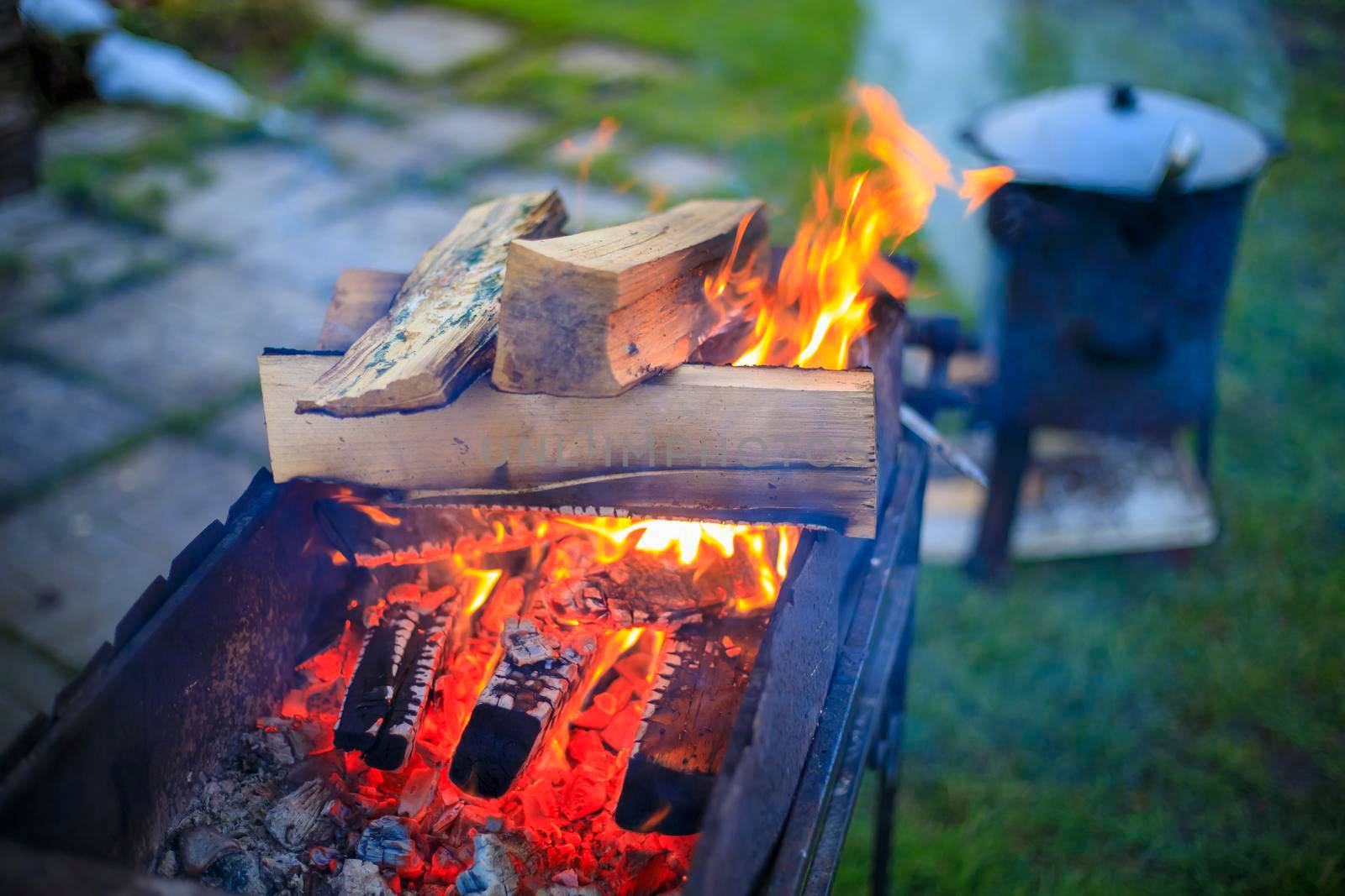 Cooking in a cauldron on the fire. Picnic outdoors in summer. Close-up