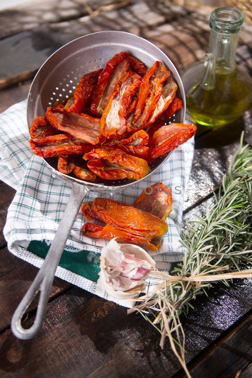 Presentation portion of dried tomatoes with rosemary in small colander