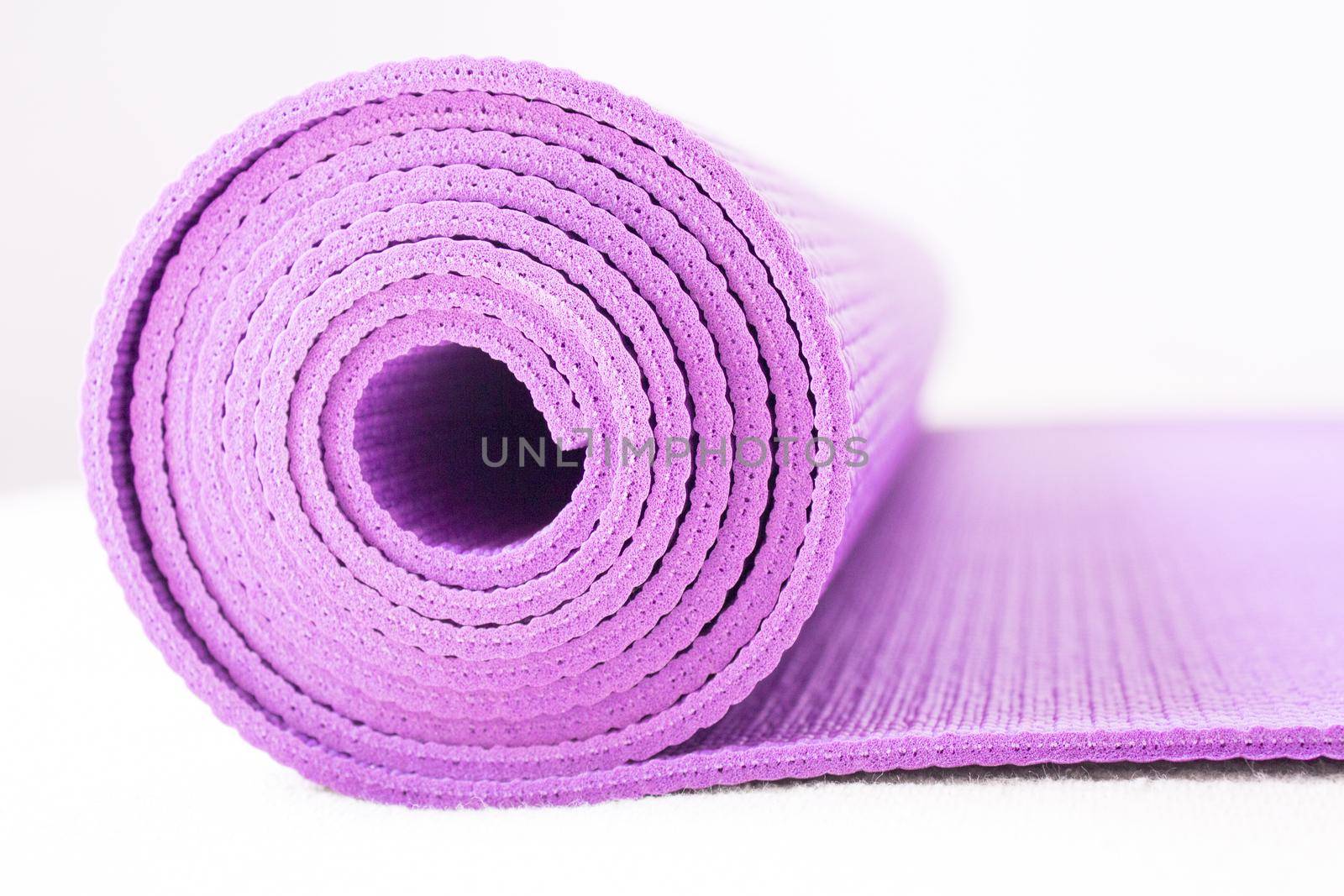 Rolled up yoga or pilates mat. No people