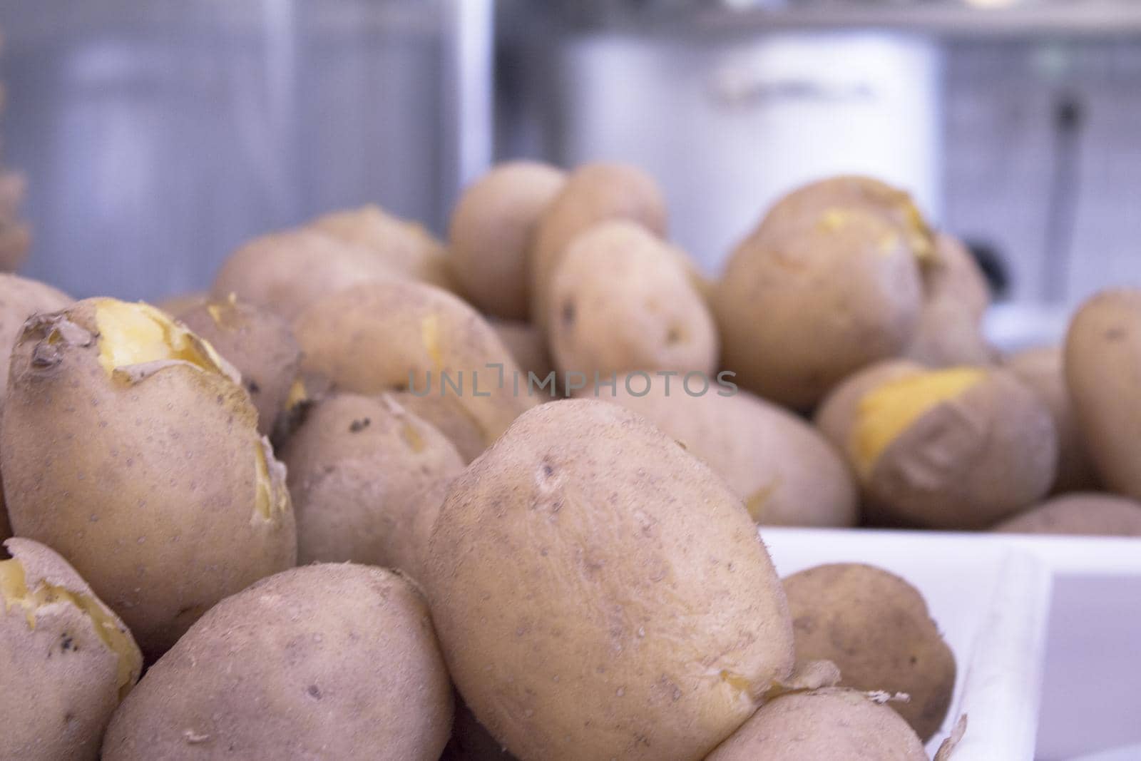 Boiled potatoes on restaurant kitchen table. No people
