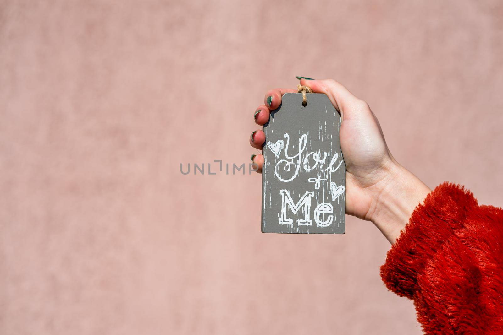 Hands holding ornament with text message you and me