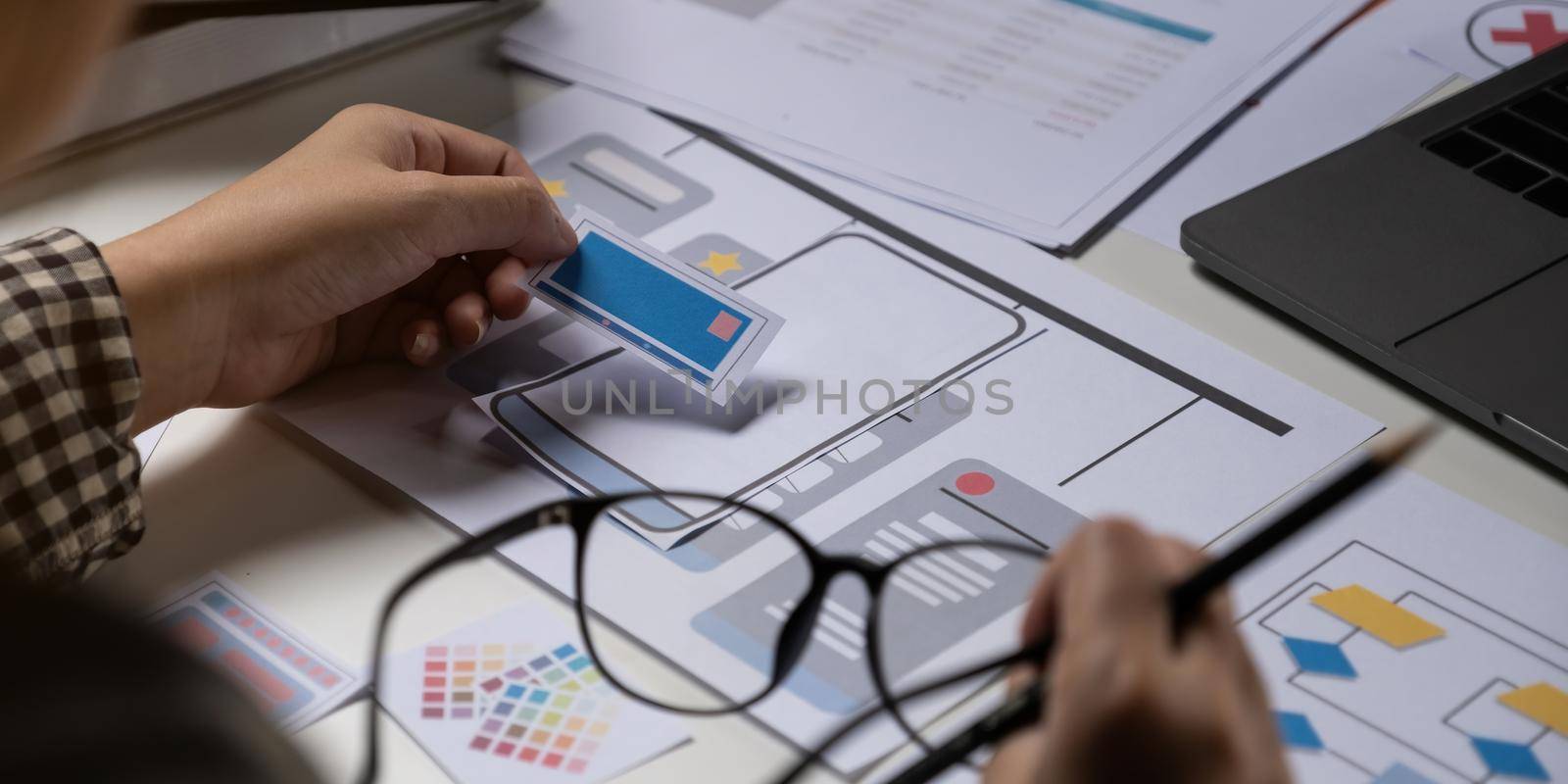 A close-up of an ux ui developer and an ui designer working on a mockup icon interface for a mobile app