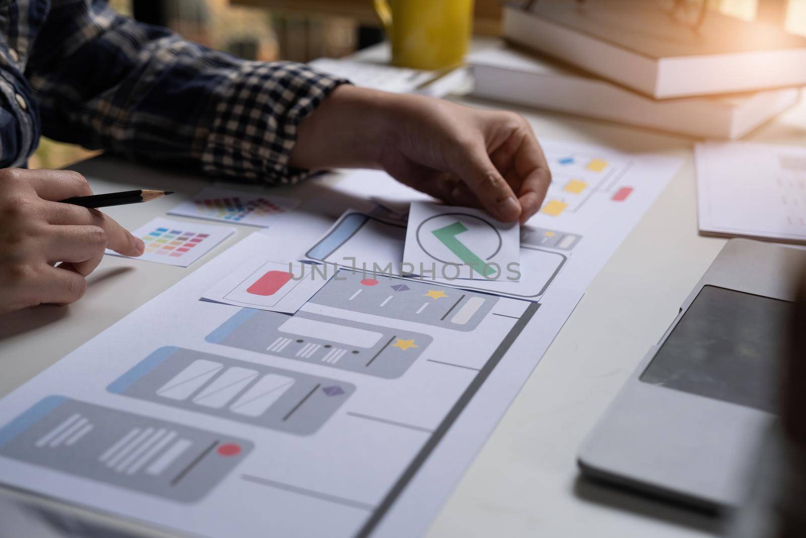 A close-up of an ux ui developer and an ui designer working on a mockup icon interface for a mobile app. by itchaznong