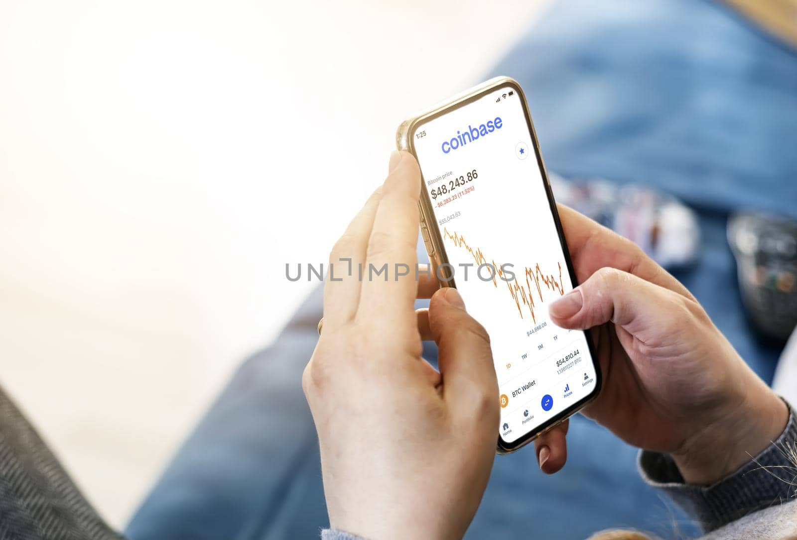 San Francisco, CA, USA, April 7 2021: Woman checking cryptocurrency quotes on her smart phone using the Coinbase app. Business and technology. Exchange of cryptocurrencies. Digital finance and the stock market