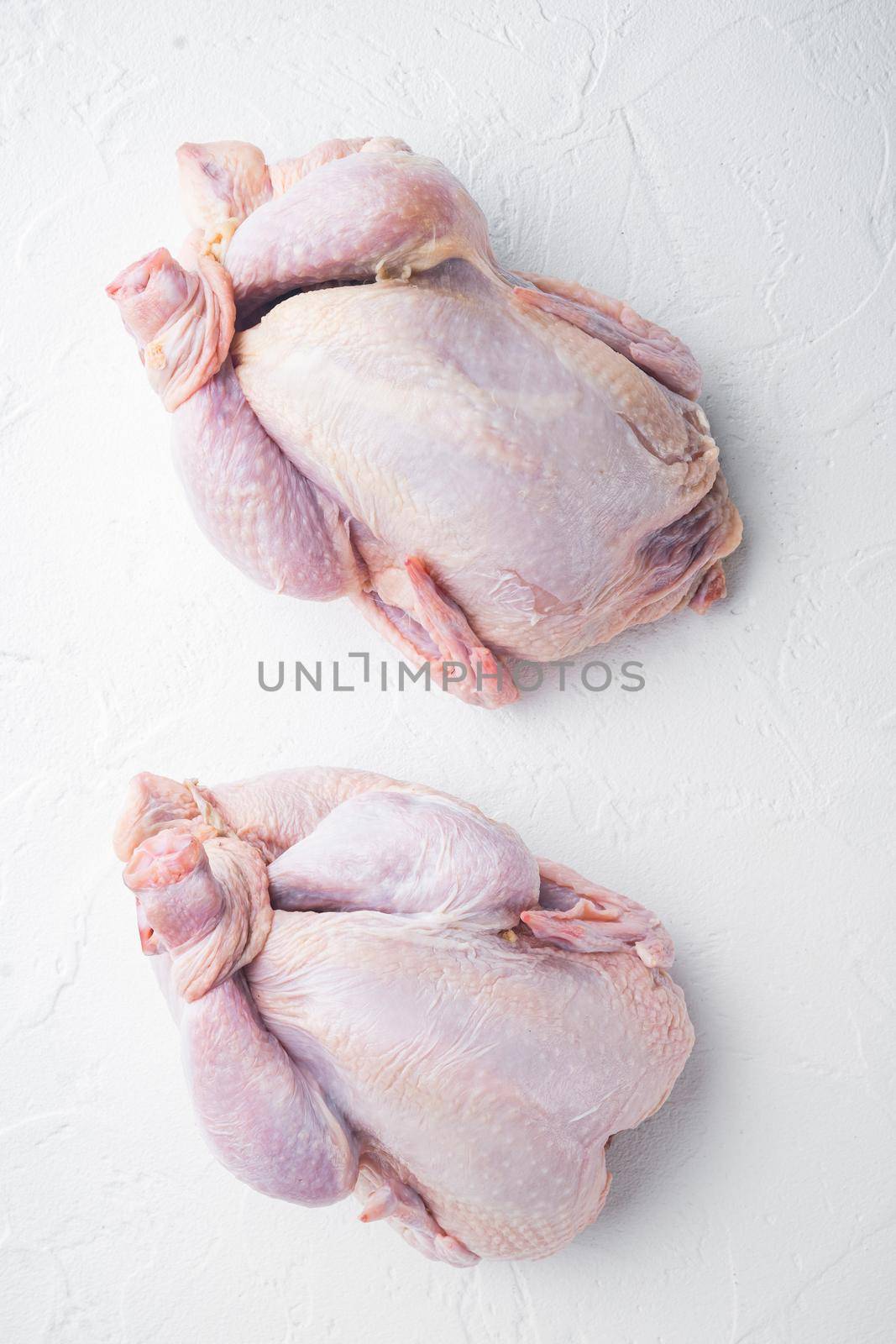 Fresh raw whole chicken carcass, on white background, top view