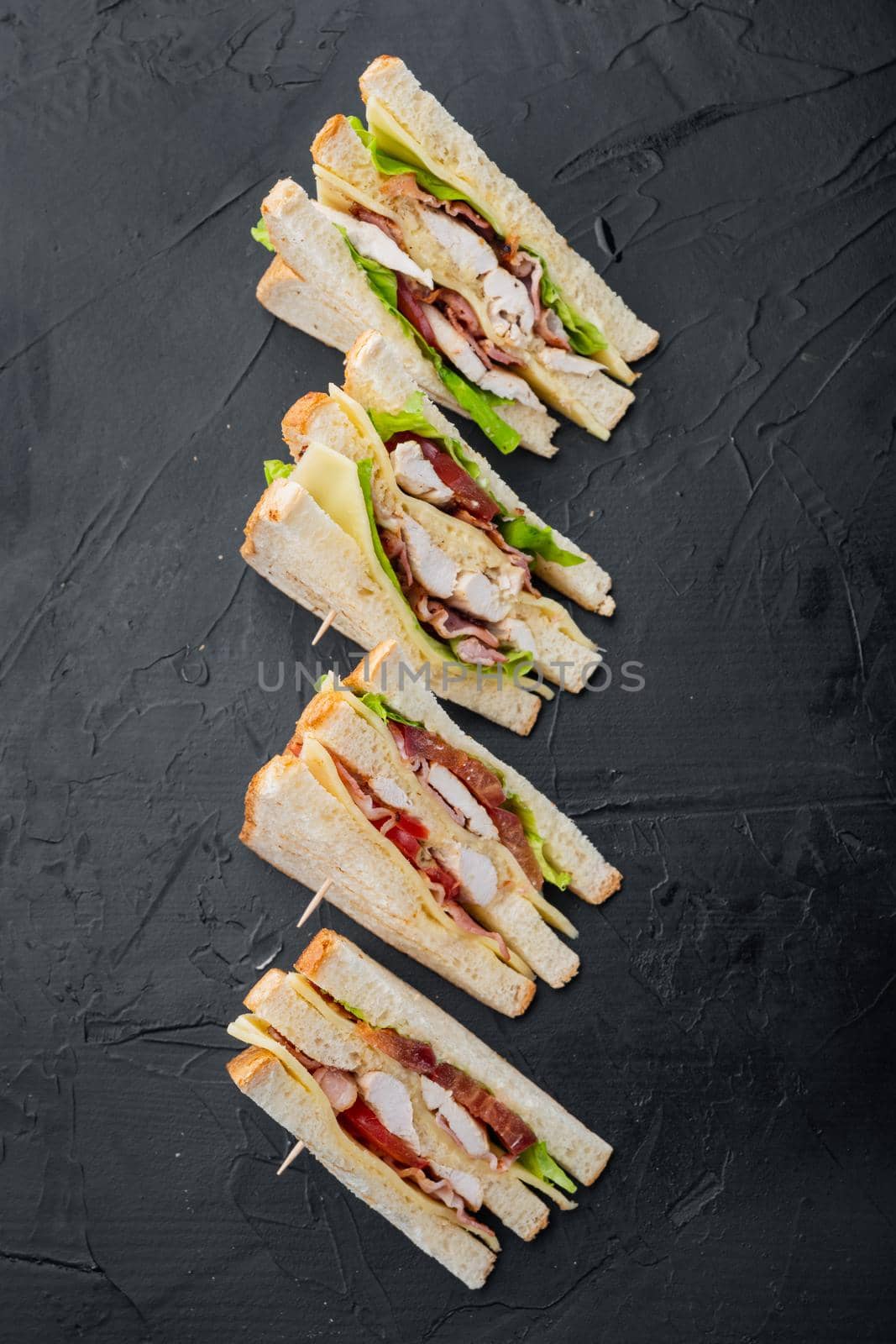 Fresh sandwiches with ingredient, on black background, top view