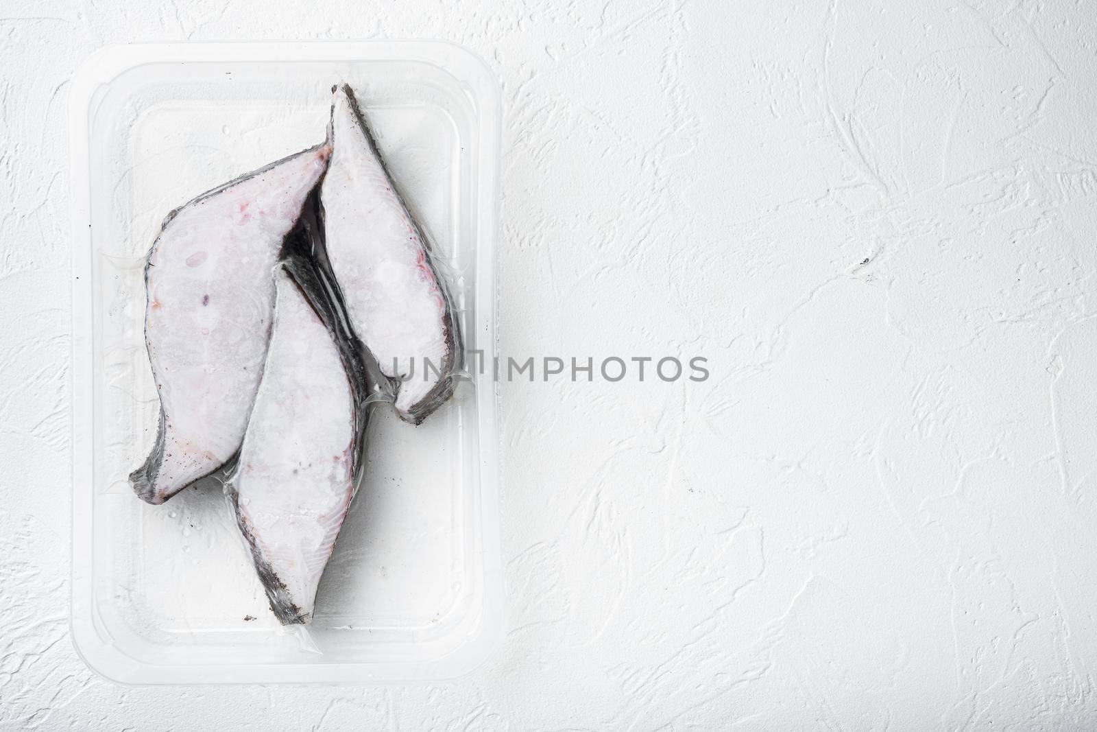 Halibut fish frozen steak pack set, on white stone table background, top view flat lay, with copy space for text
