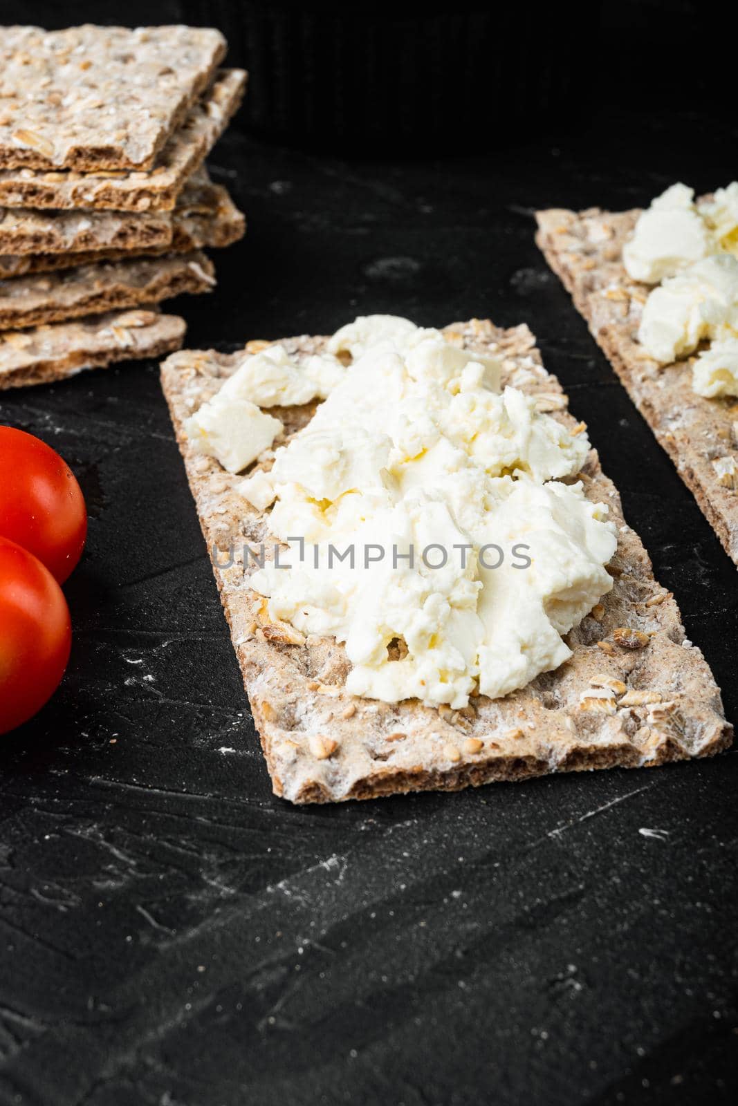 Homemade Crisp bread toast with Cottage Cheese set, on black dark stone table background, with copy space for text