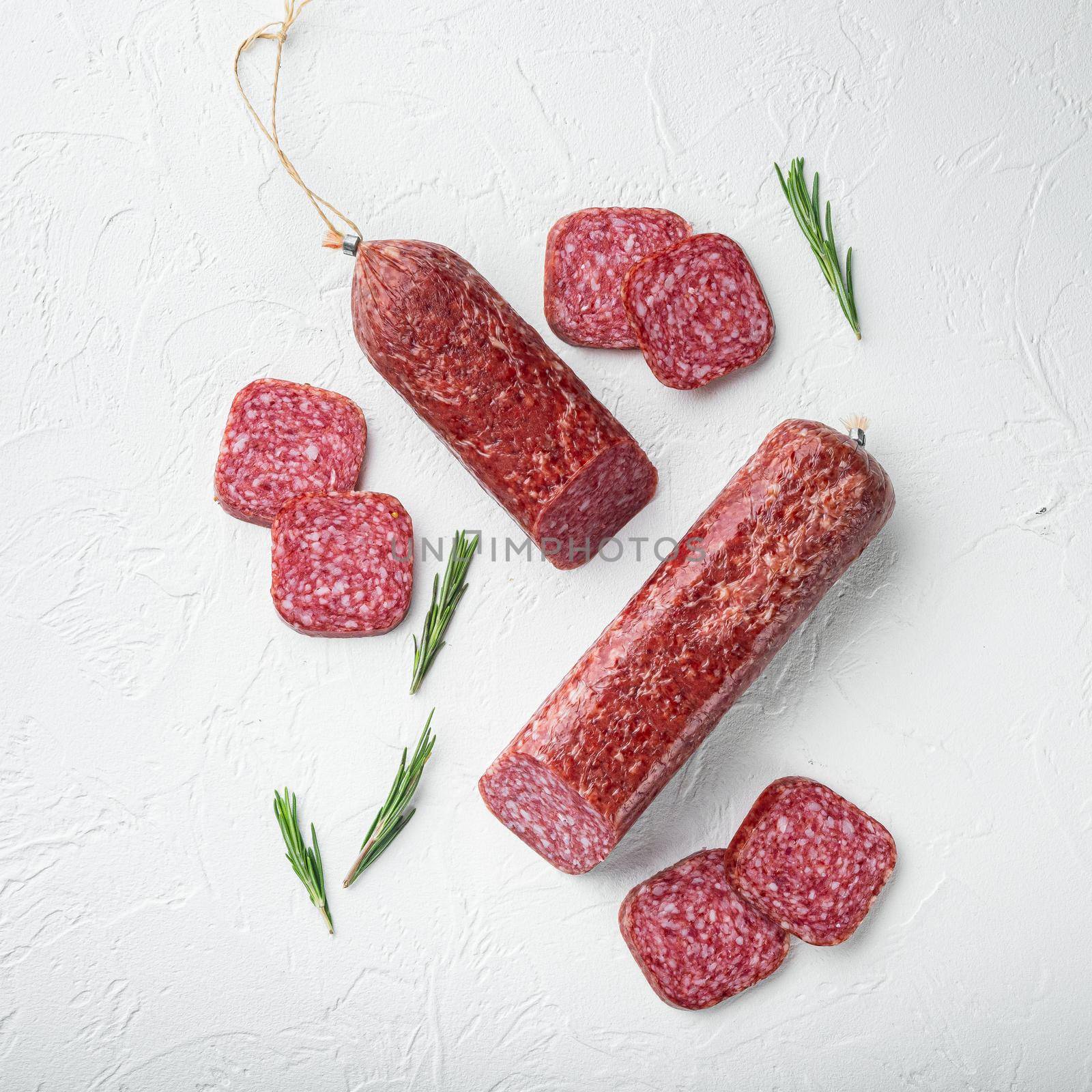 Salami with herbs , garlic , square format, on white stone table background, top view flat lay by Ilianesolenyi