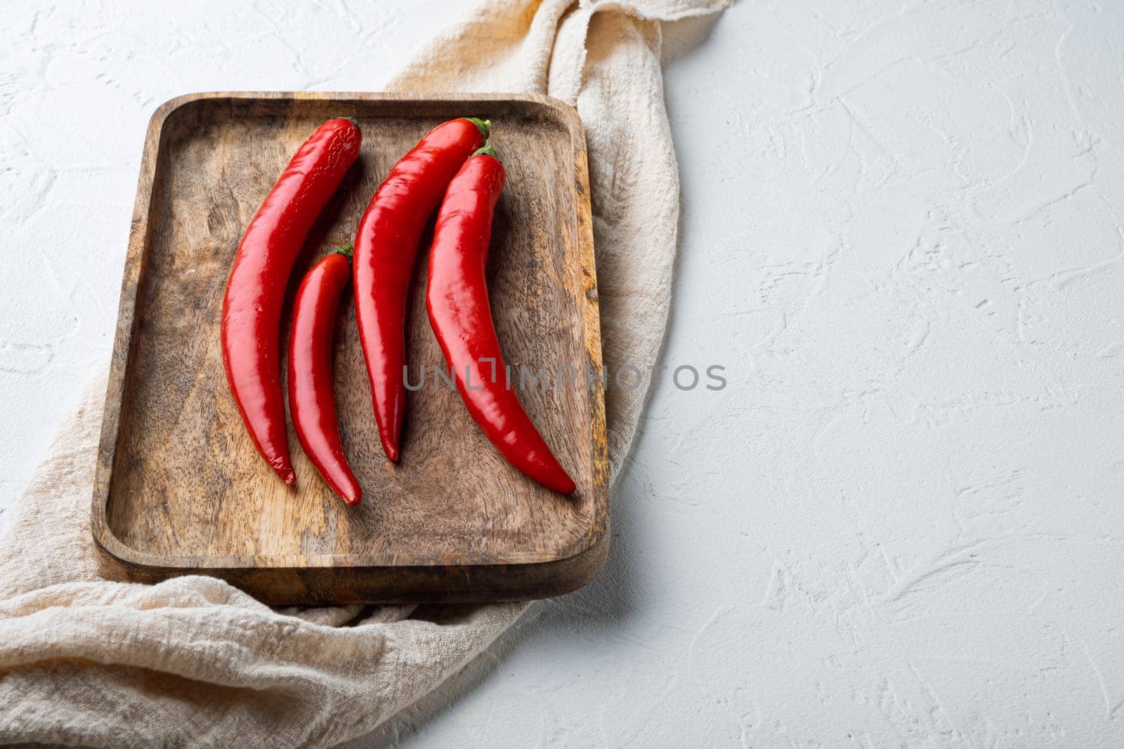 Raw red chili pepper set, on white textured background with space for text
